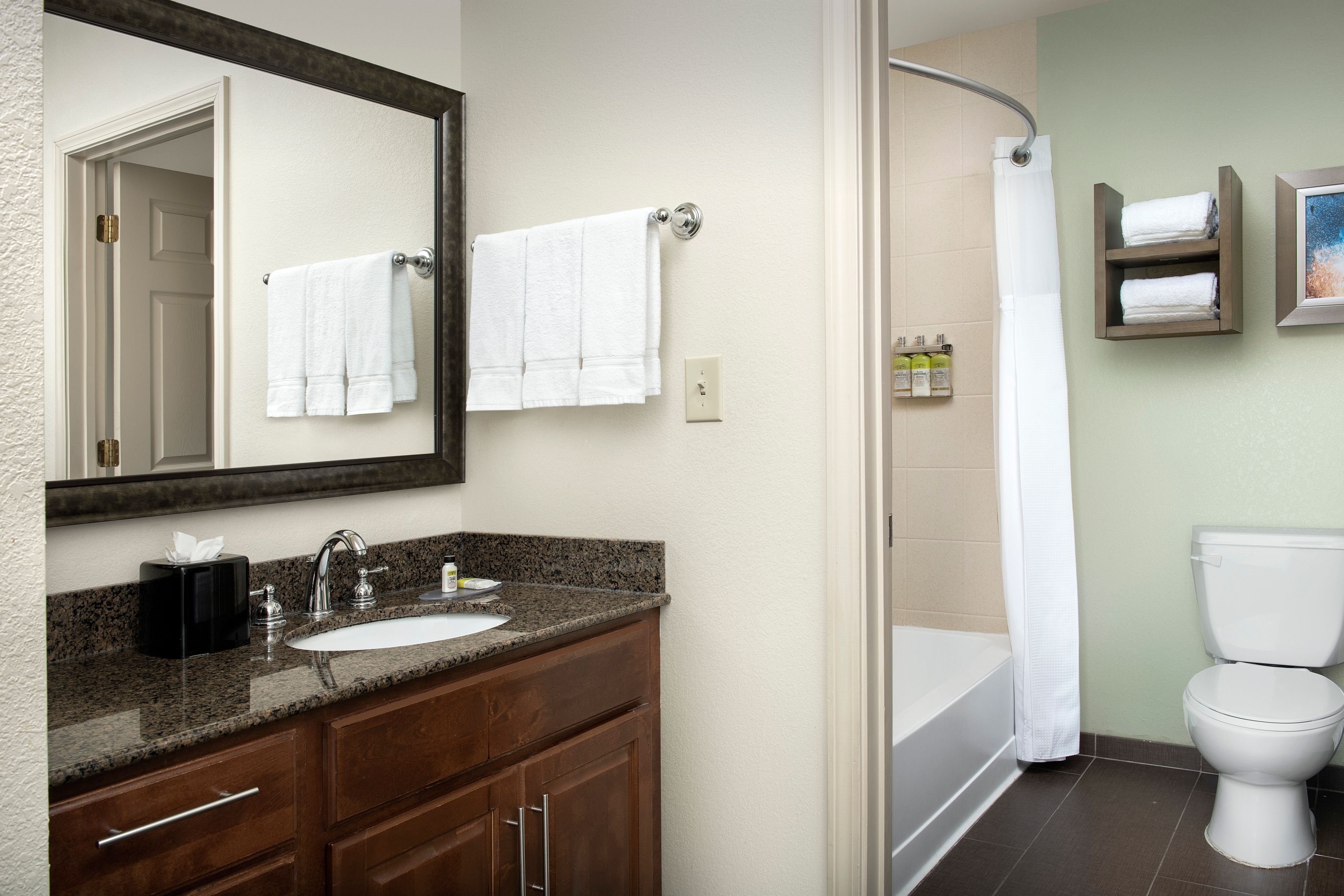 image Clean bathroom with vanity sink, mirror, and walk-in shower.