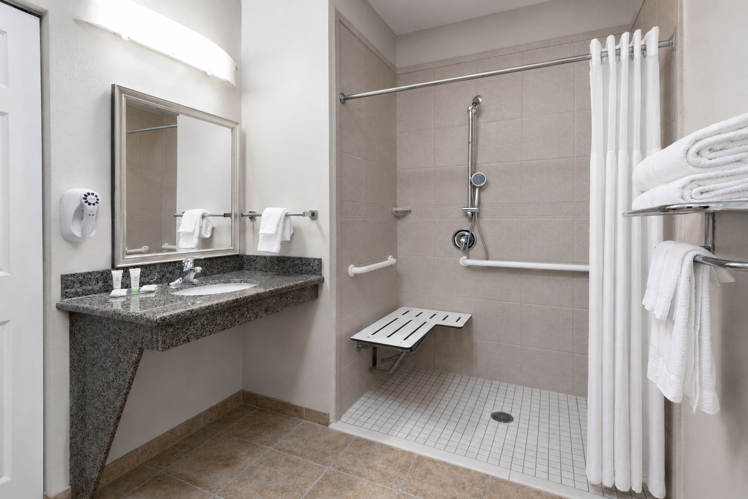 image Accessible bathroom featuring a sink, transfer shower, and grab bars.