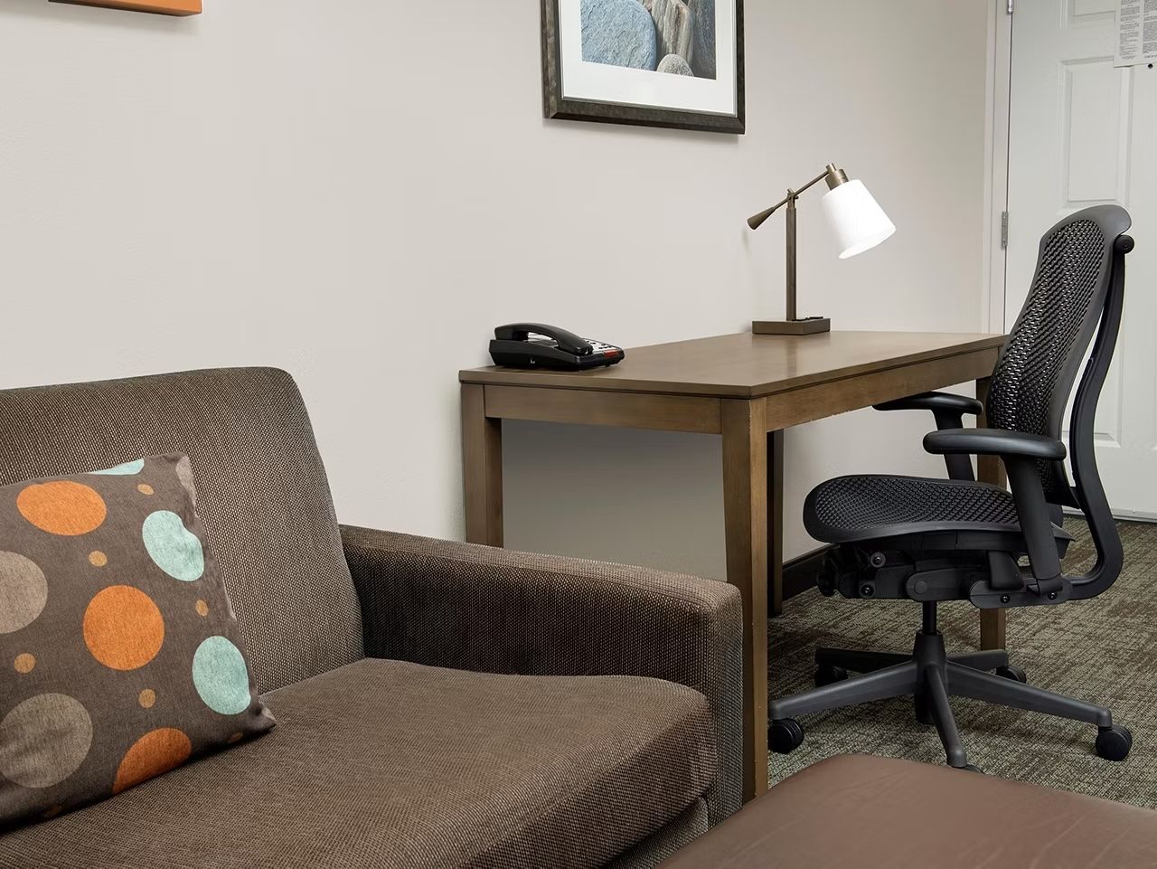 image Cozy living area with sofa bed and dedicated work desk.