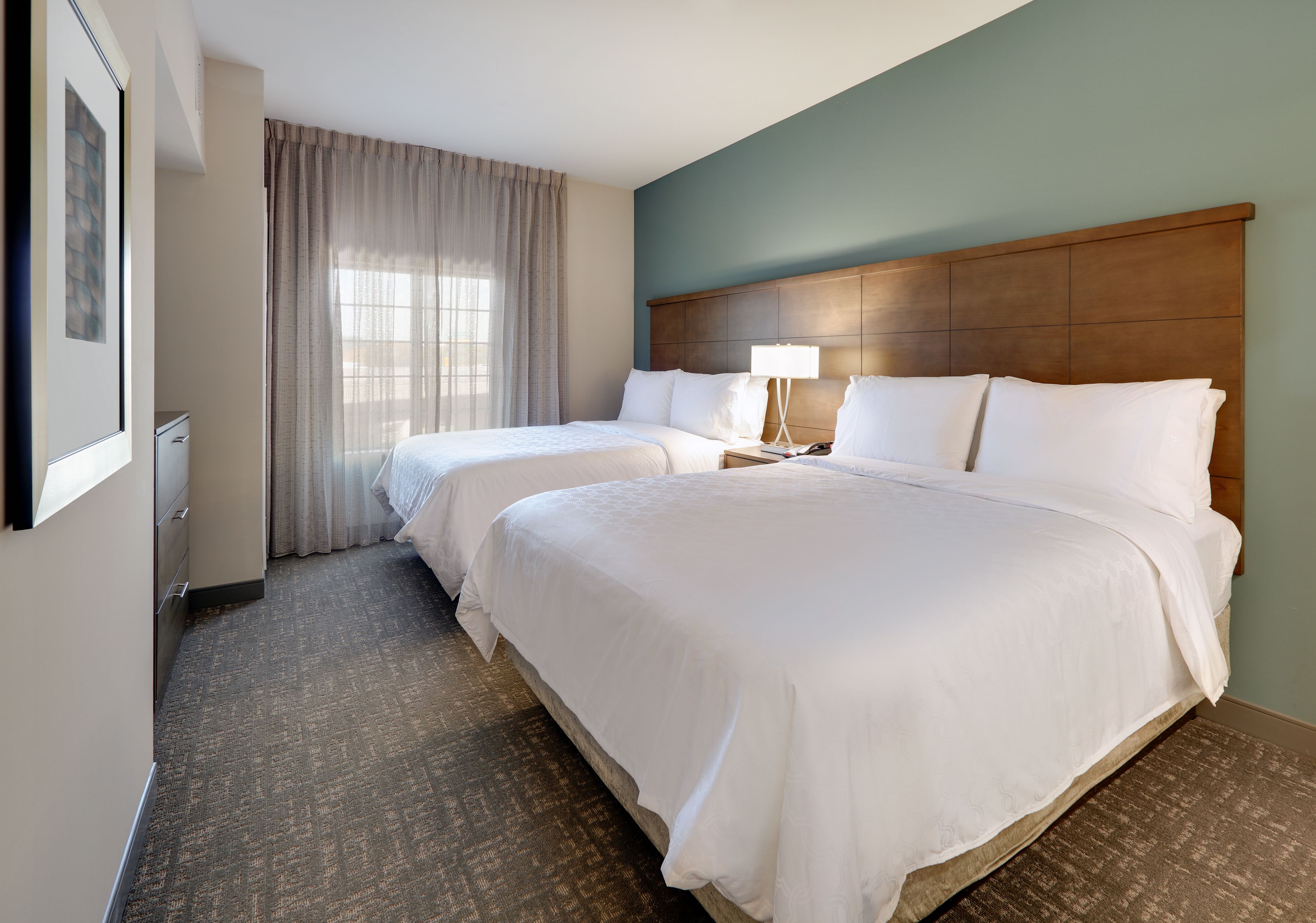 image Bright bedroom with two queen beds and soft linens.