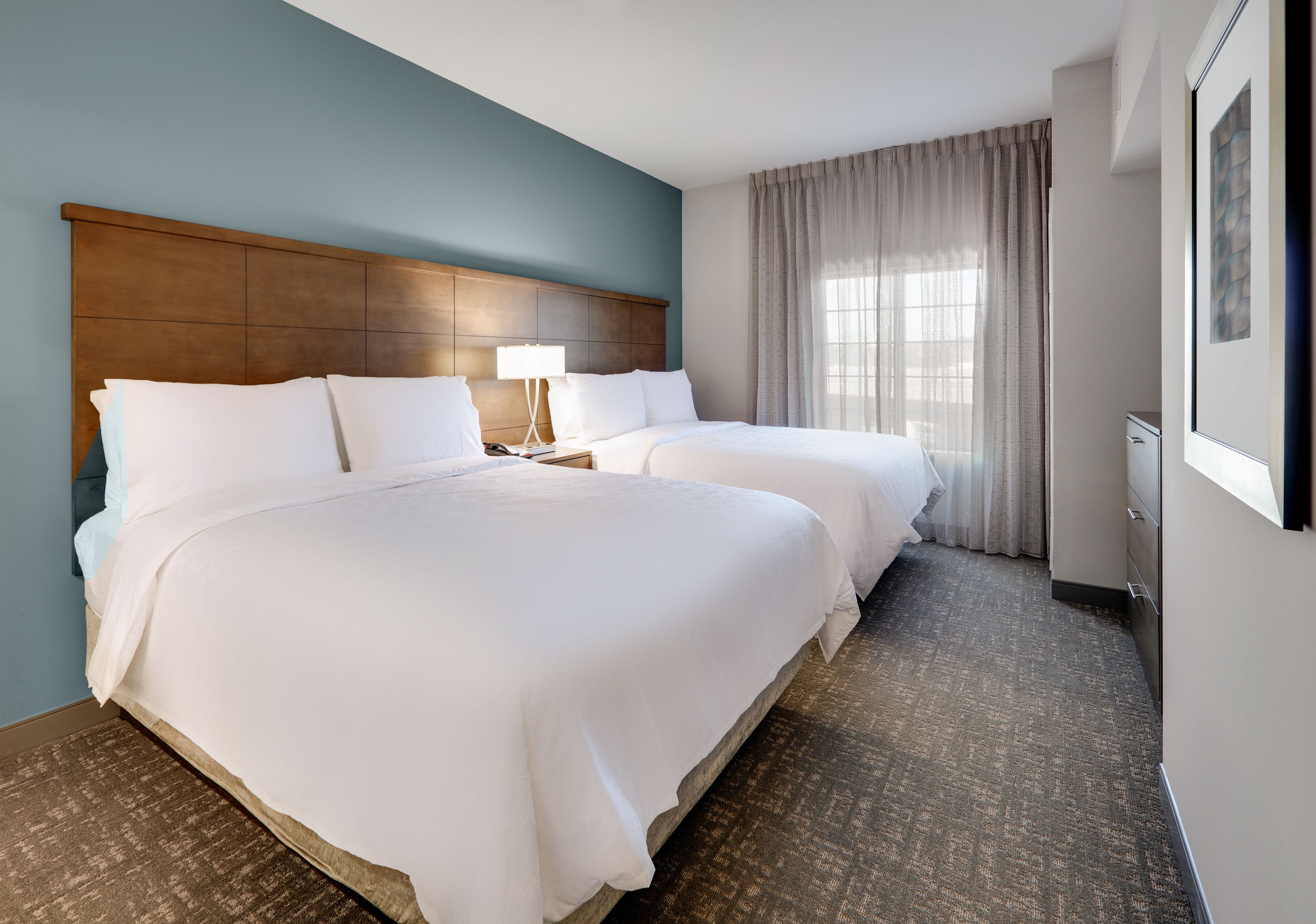 image Private bedroom with two queen beds and modern furnishings.