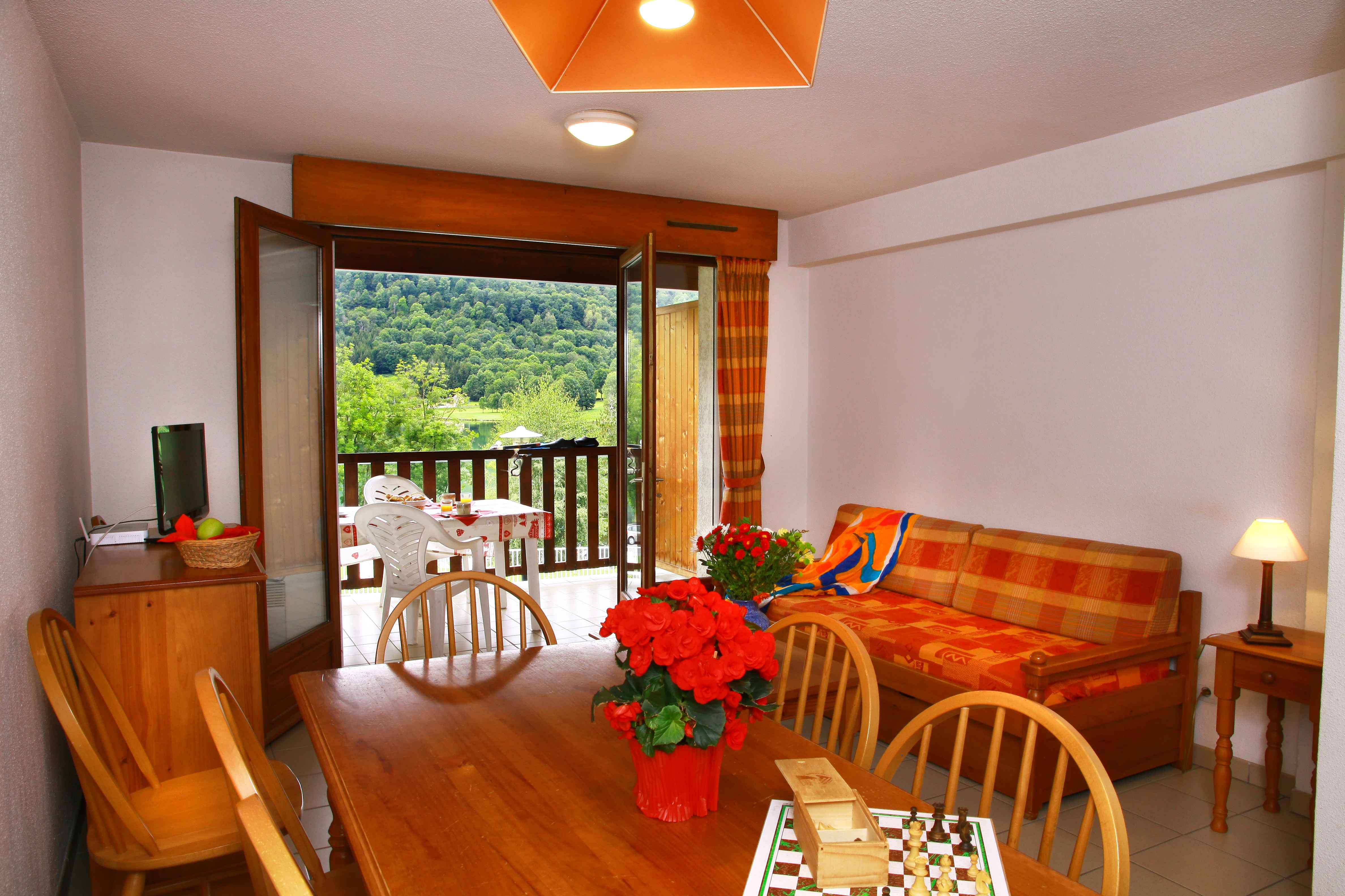 image The spacious living area with balcony access is perfect for gathering after a day skiing in Peyragudes or hiking the scenic trails around Lake Génos.