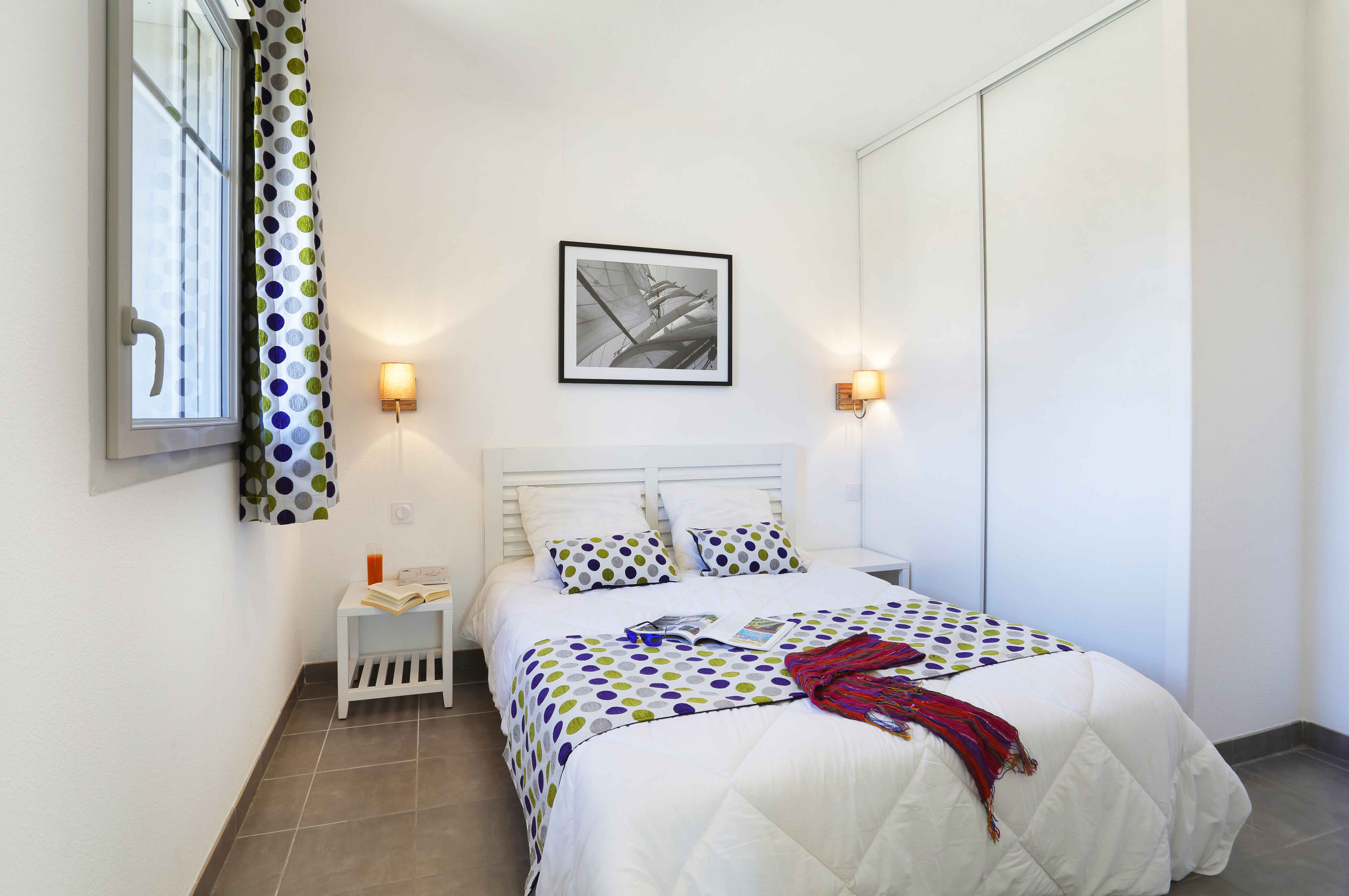 image Double bedroom upstairs with soft bedding and curtained window — one of two bedrooms in this 44 m² duplex.