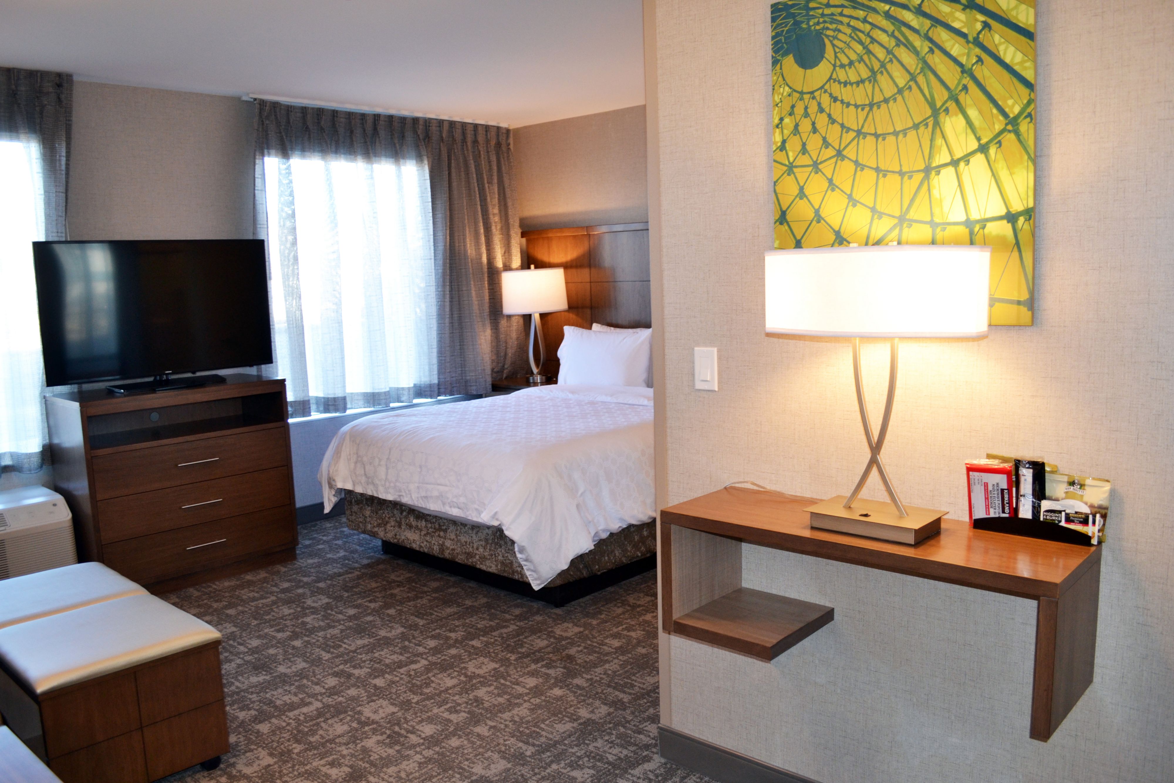 image Cozy queen studio suite with spacious living area and TV.