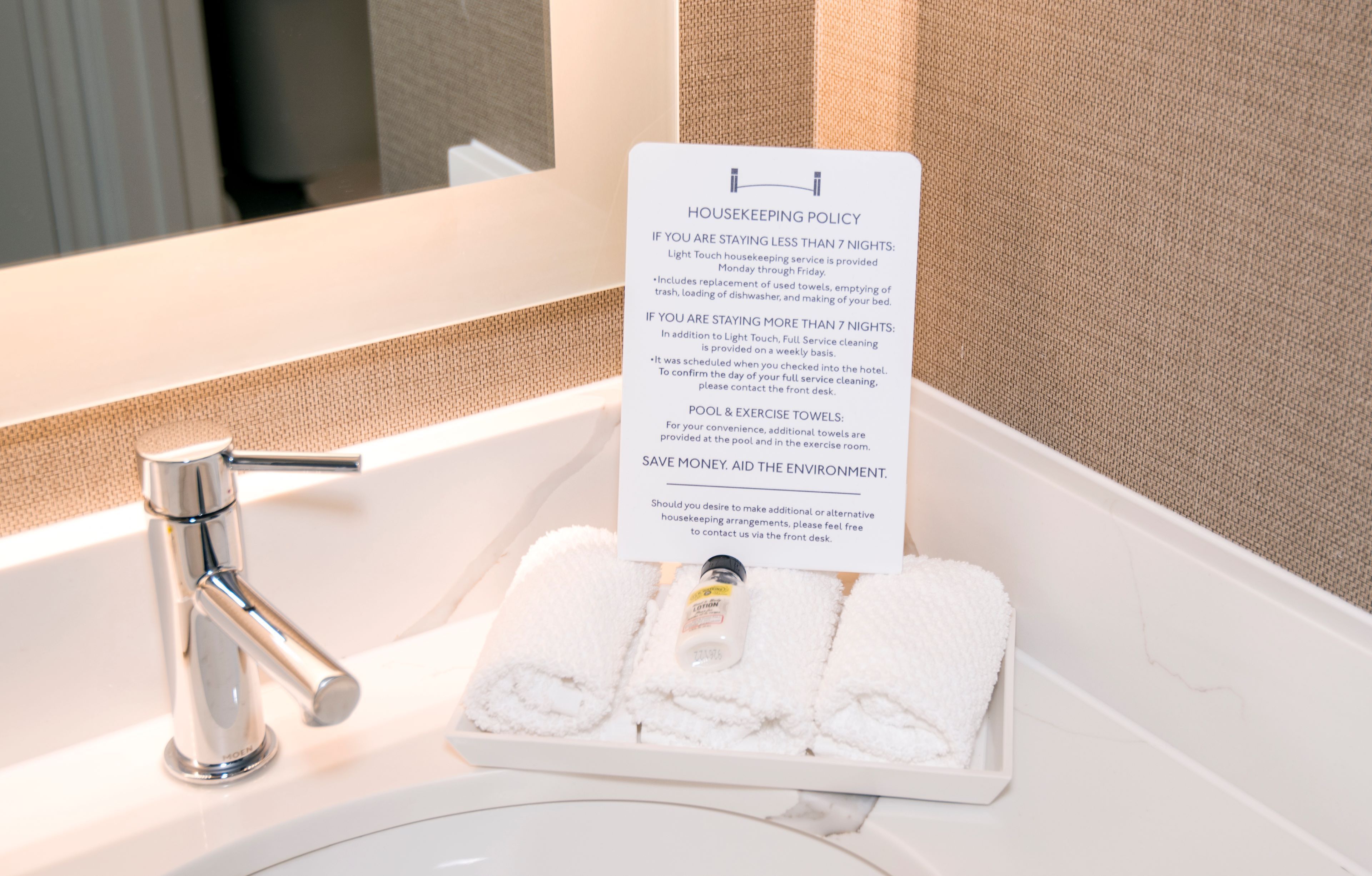 image Bathroom vanity with sink, towels, and in-room amenities.