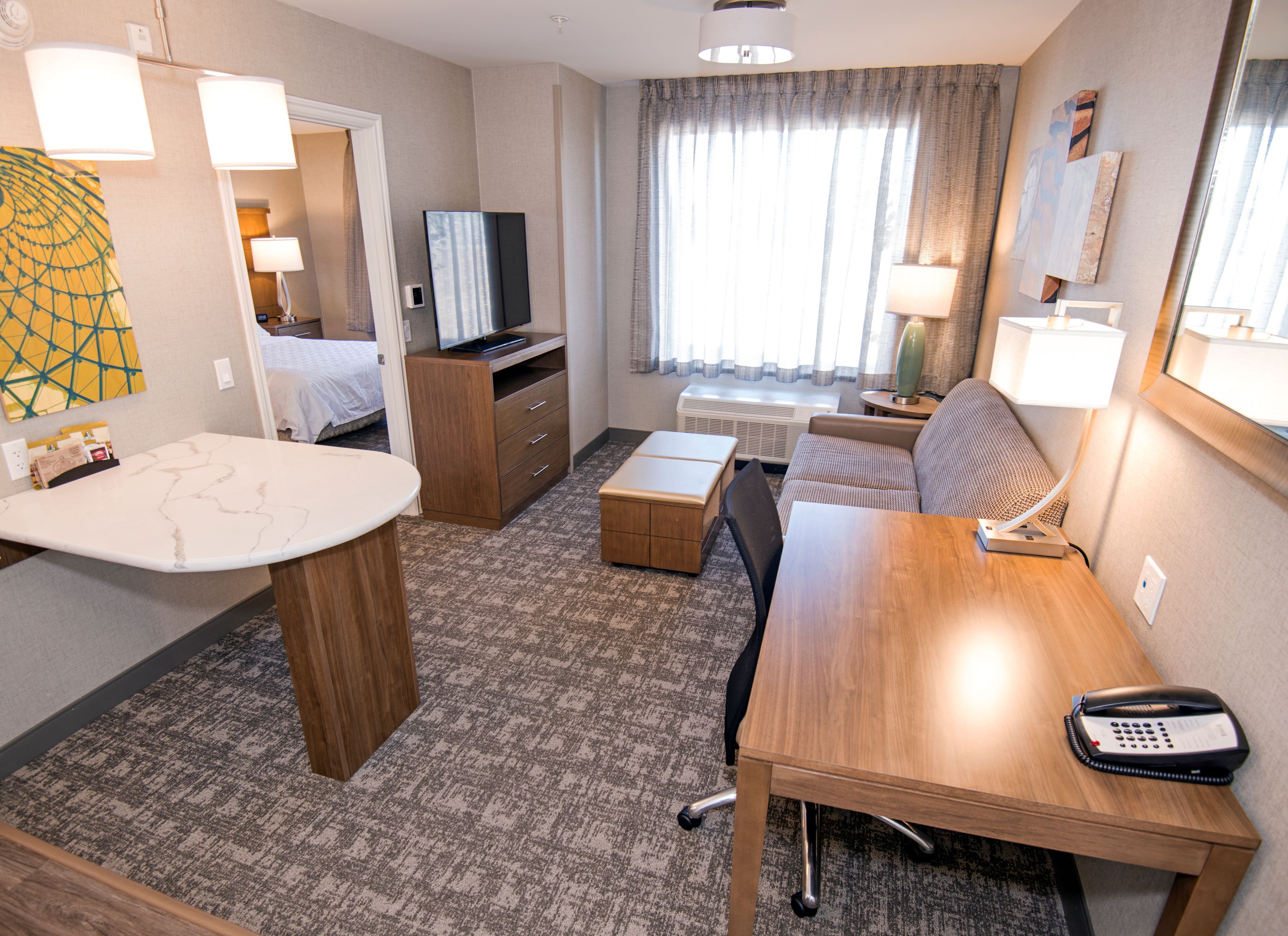 image Spacious accessible suite with comfortable sitting area and work desk.