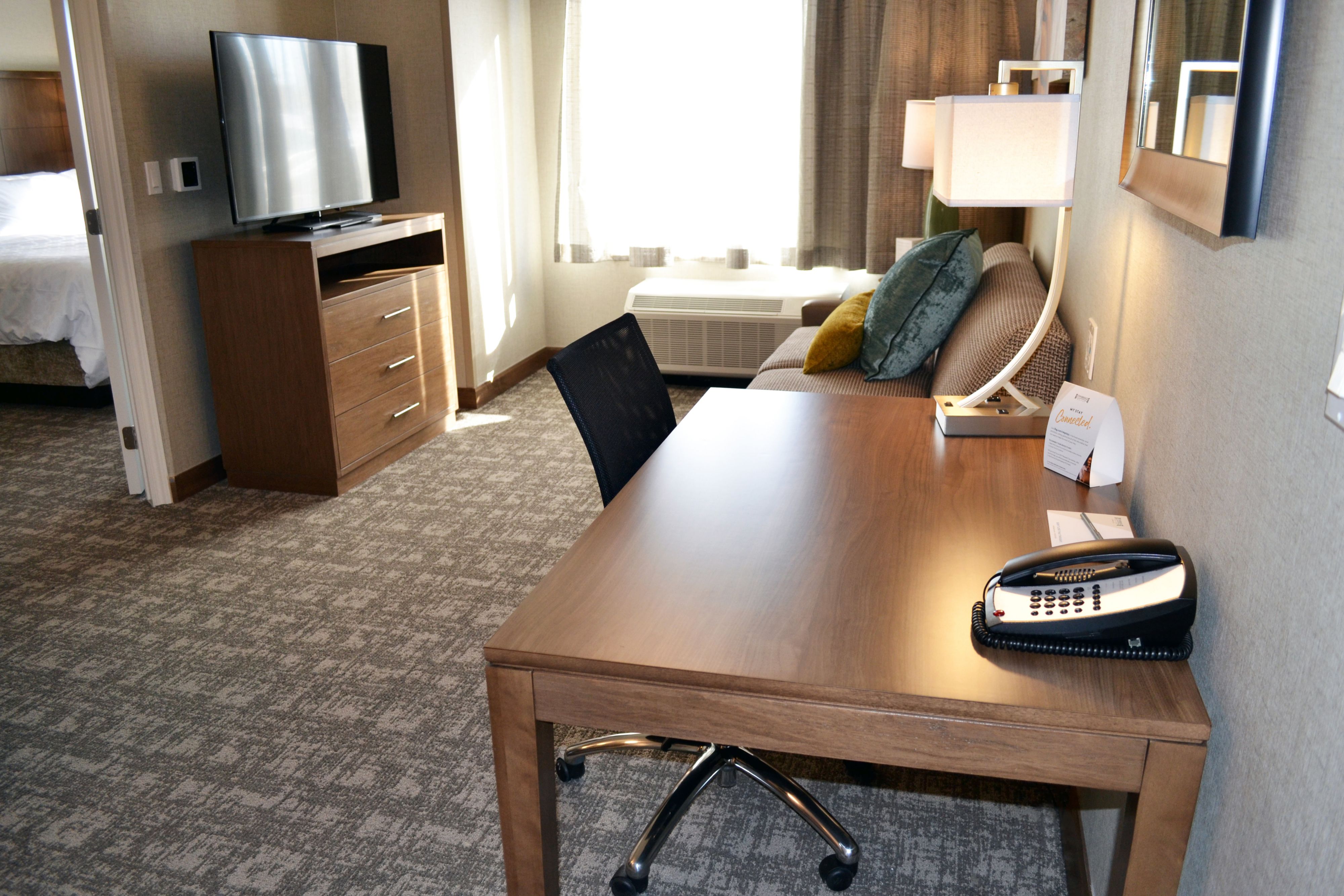 image Living area with sofa, desk, and flat-screen TV.