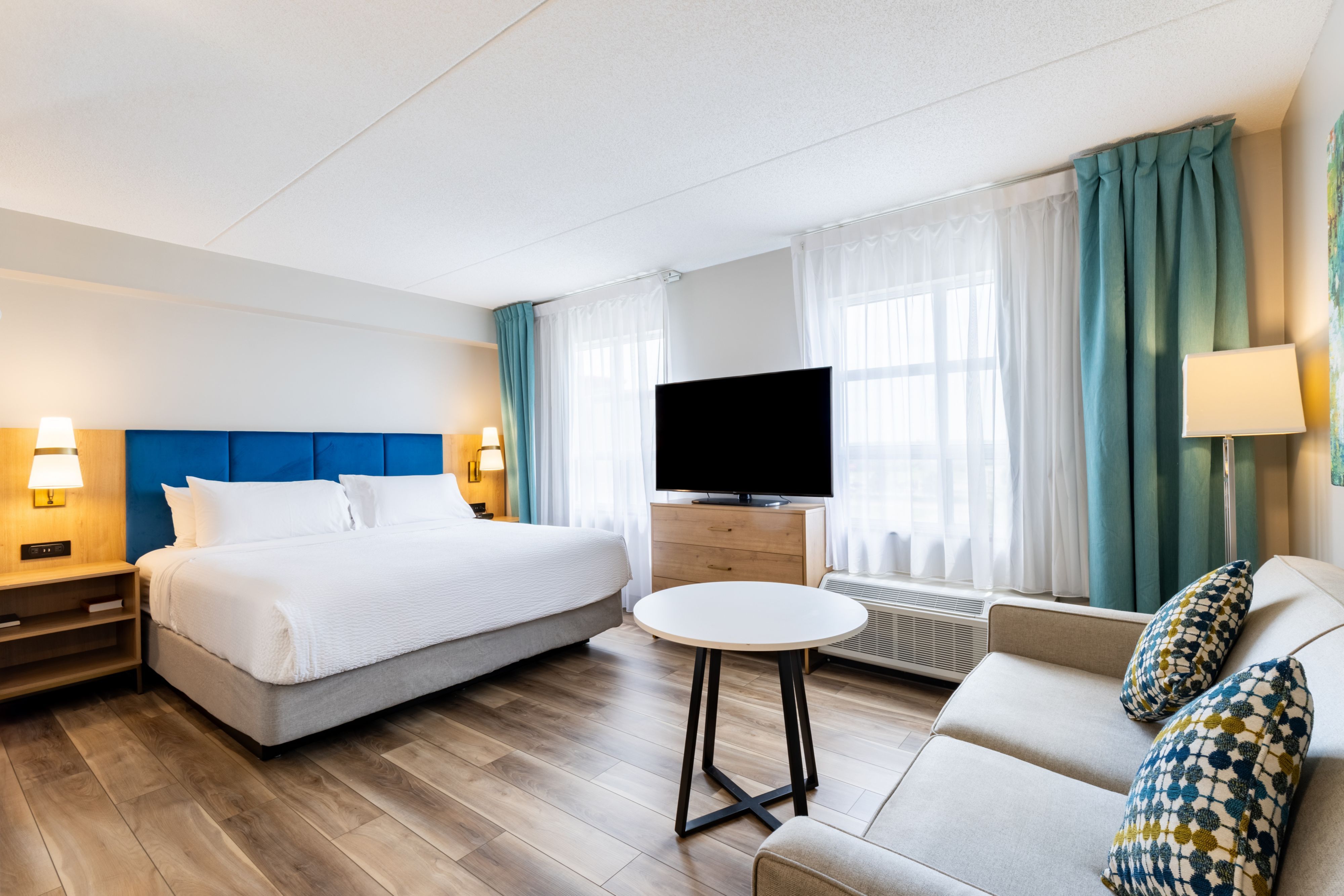 image King bed studio with comfortable seating and warm lighting.