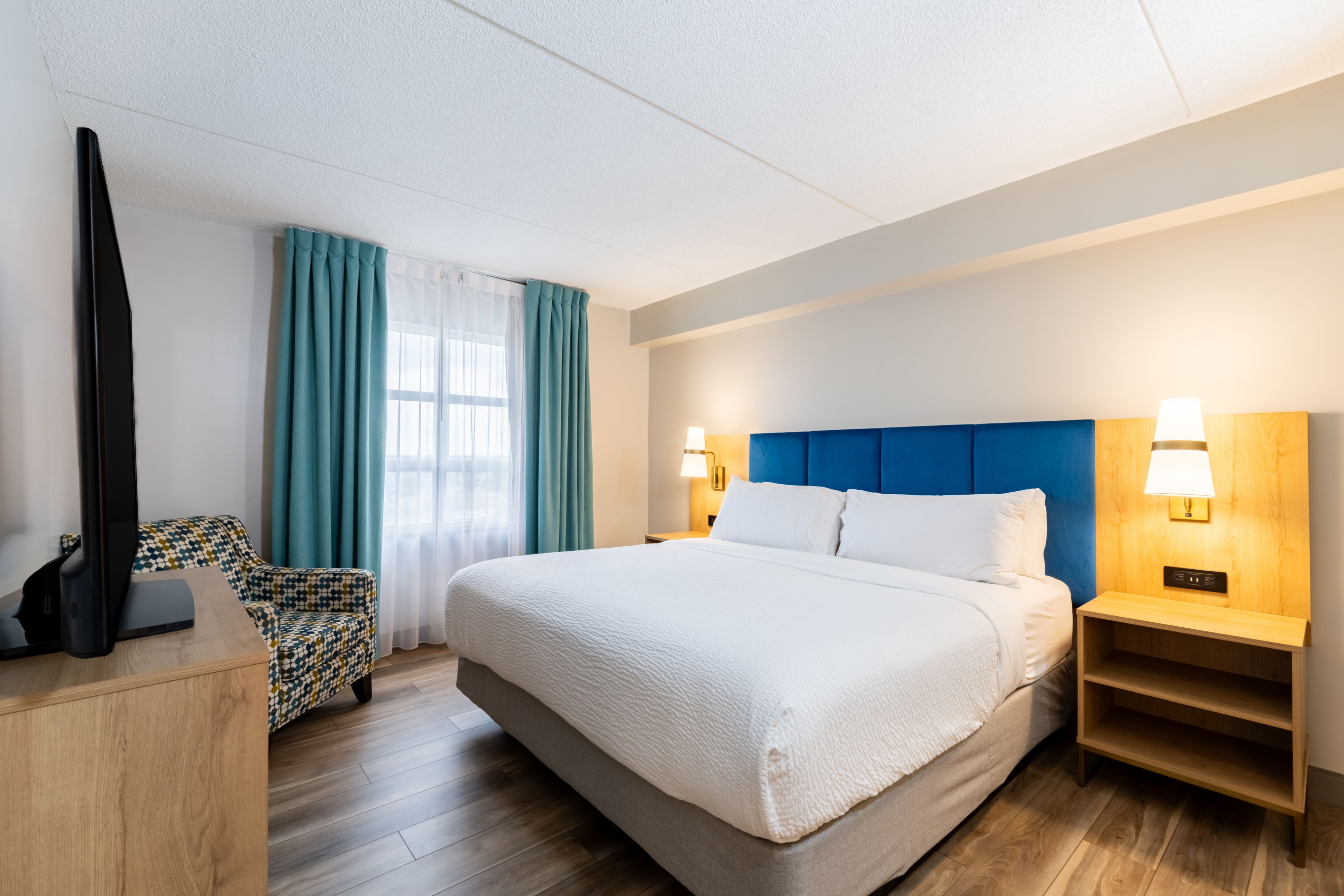 image Modern guest room with a king bed and stylish decor elements.
