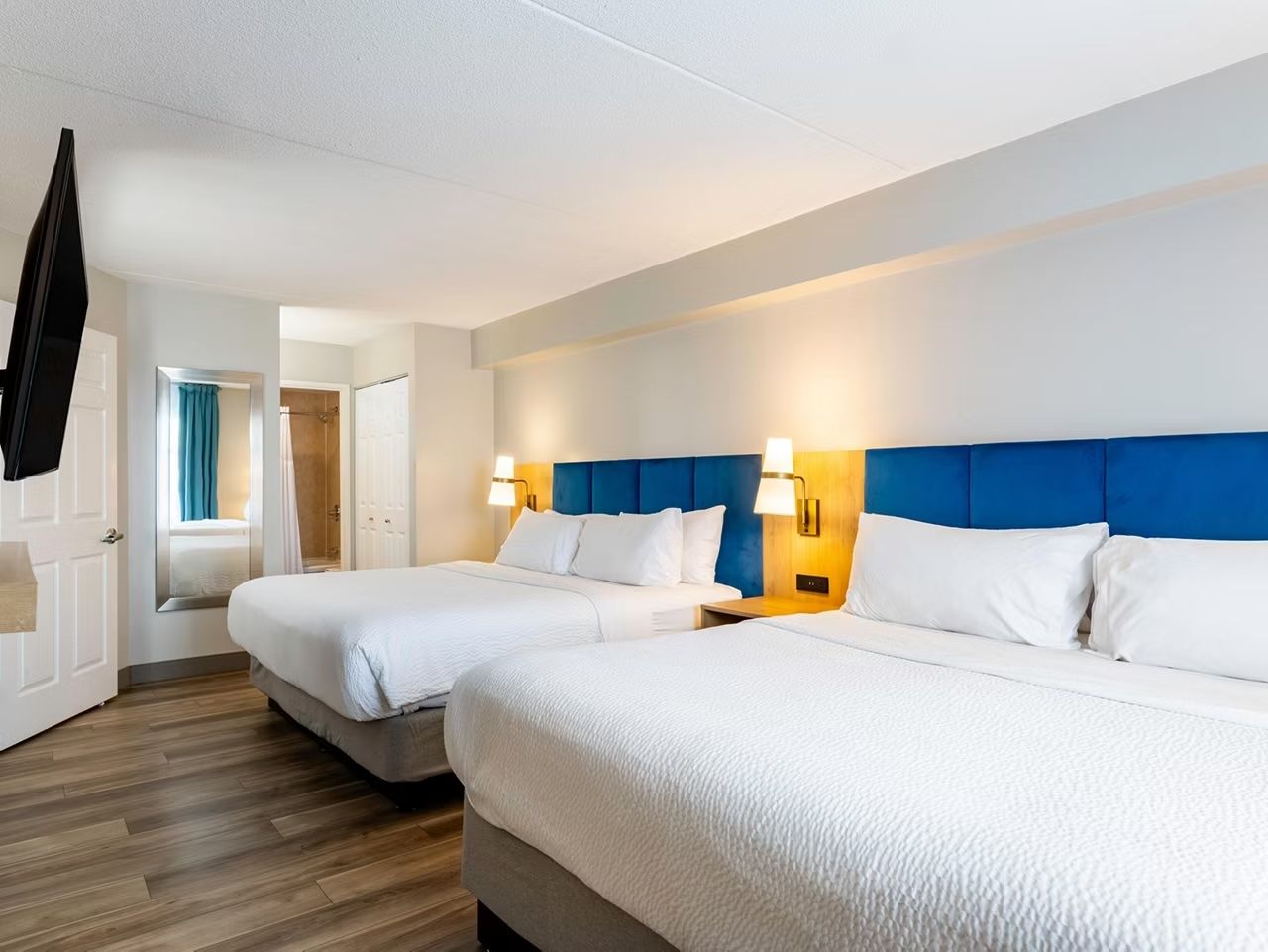 image Spacious dual-bed room designed for comfort with warm lighting.