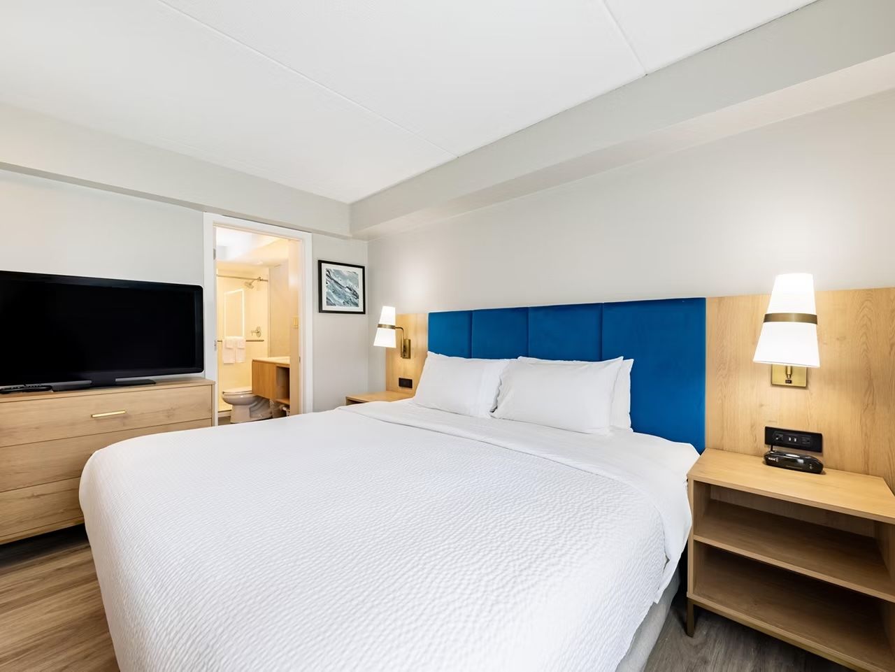 image King bed studio with flat-screen TV and warm lighting.