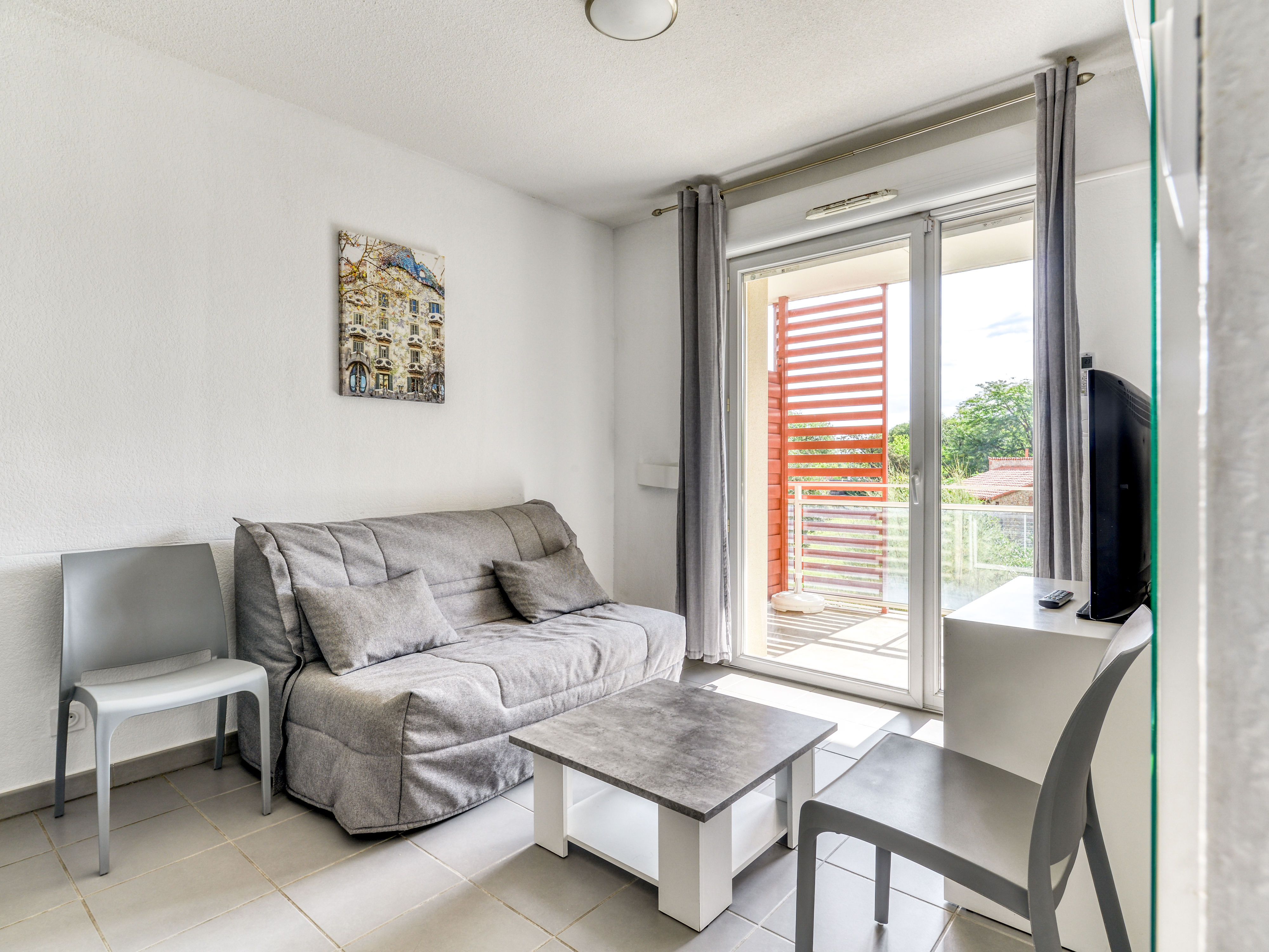 image Living area with a double sofa bed and flat-screen TV — air conditioning keeps things cool
