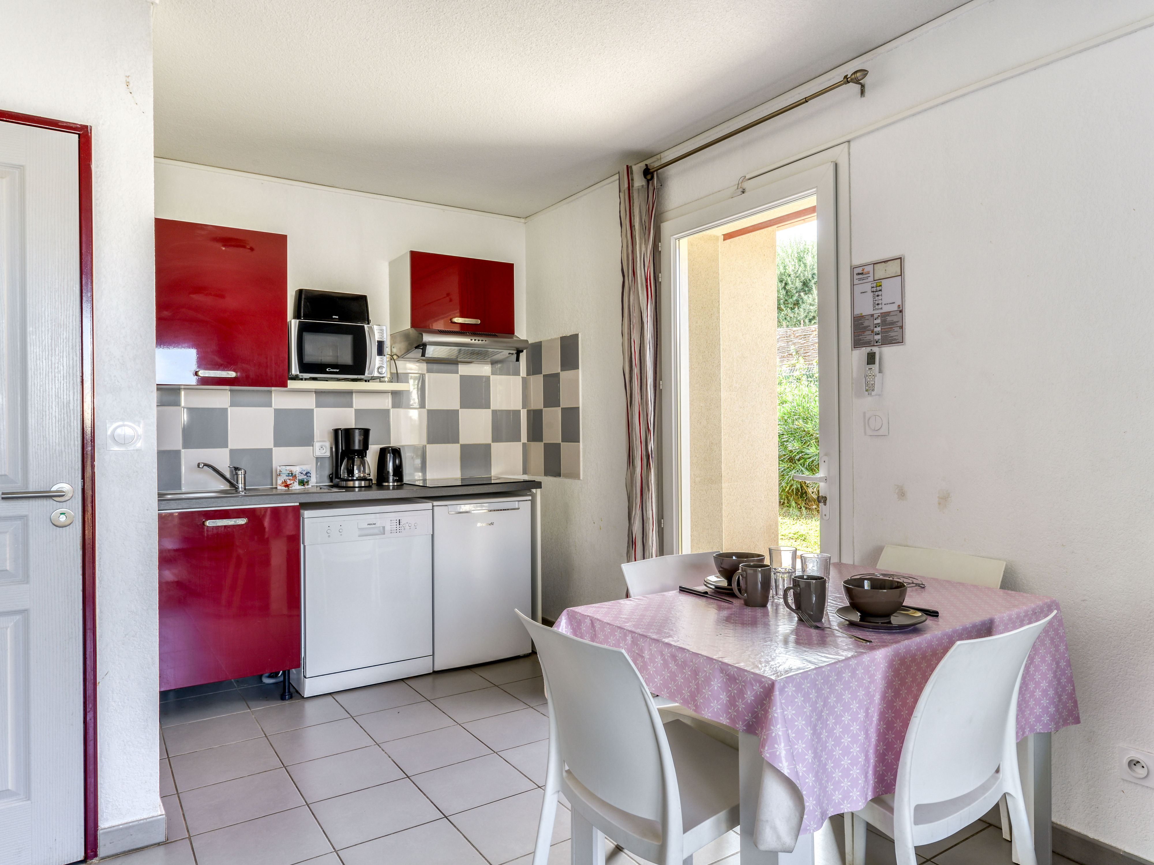 image Red-cabinet kitchenette with ceramic hob, microwave, dishwasher, and coffee machine