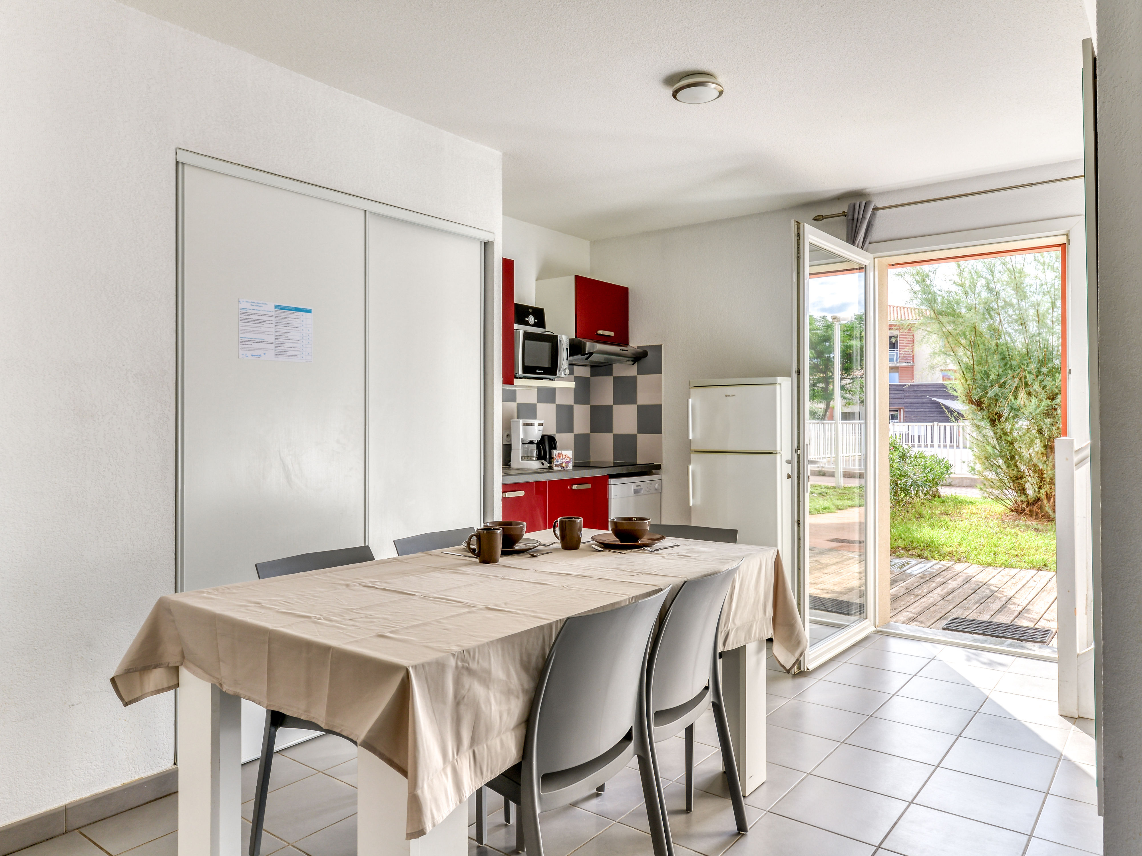 image Kitchenette with red cabinetry, ceramic hob, microwave, and dishwasher — all the essentials