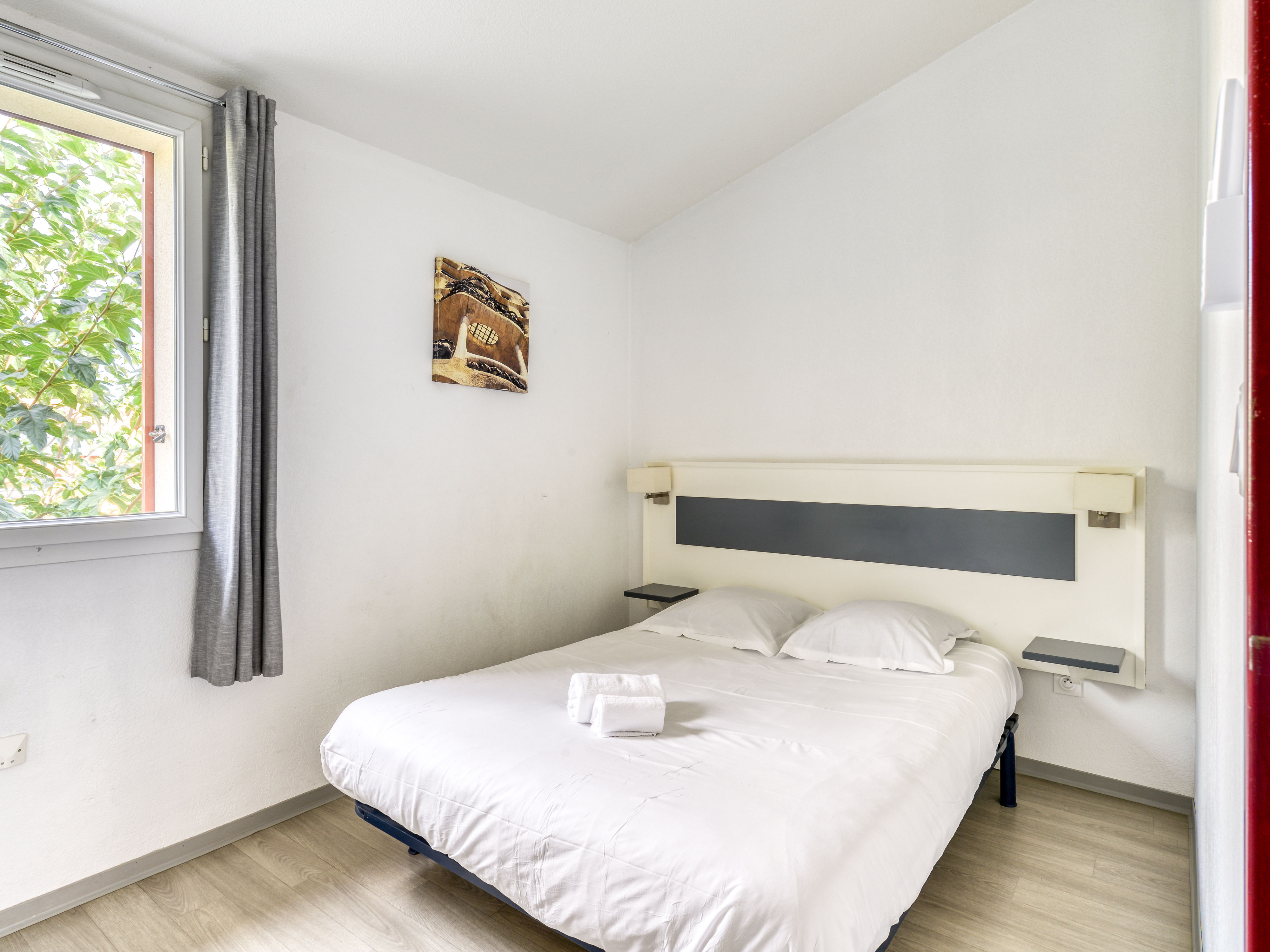 image Ground-floor double bedroom with soft white linens and natural light from the window