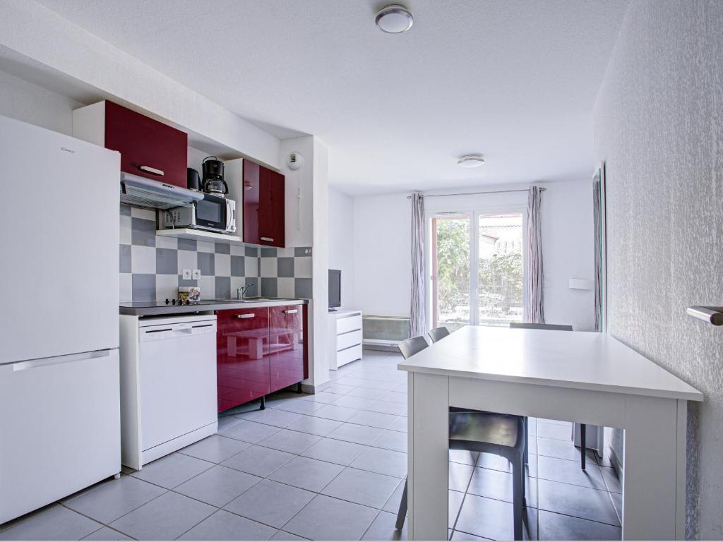 image Red-cabinet kitchenette with ceramic hob, dishwasher, and coffee machine for home-cooked meals