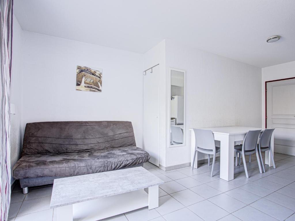 image Living area with a double sofa bed, flat-screen TV, and air conditioning — pool access just outside