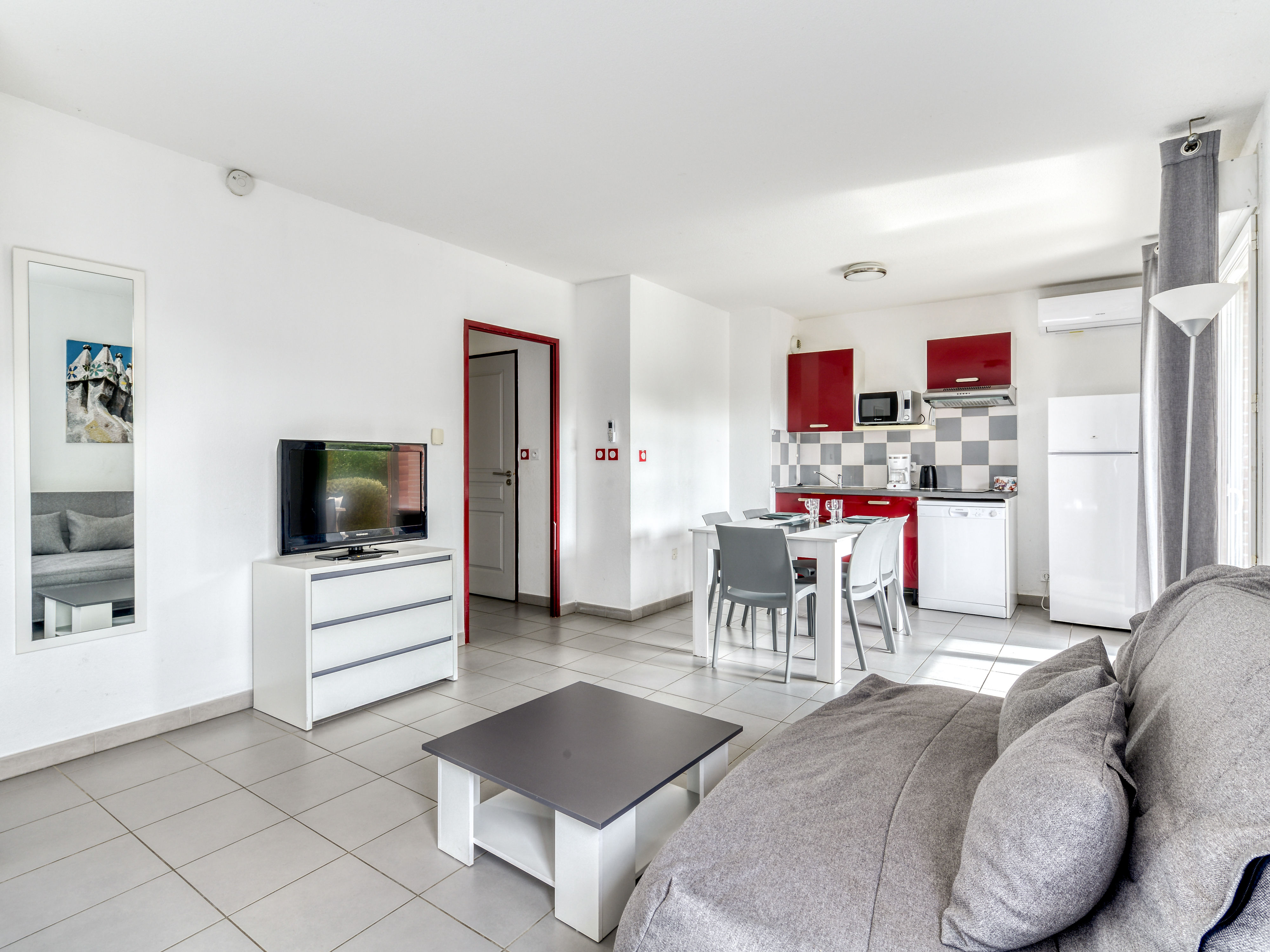 image Sunlit open-plan layout with the living area and kitchenette sharing a bright single space