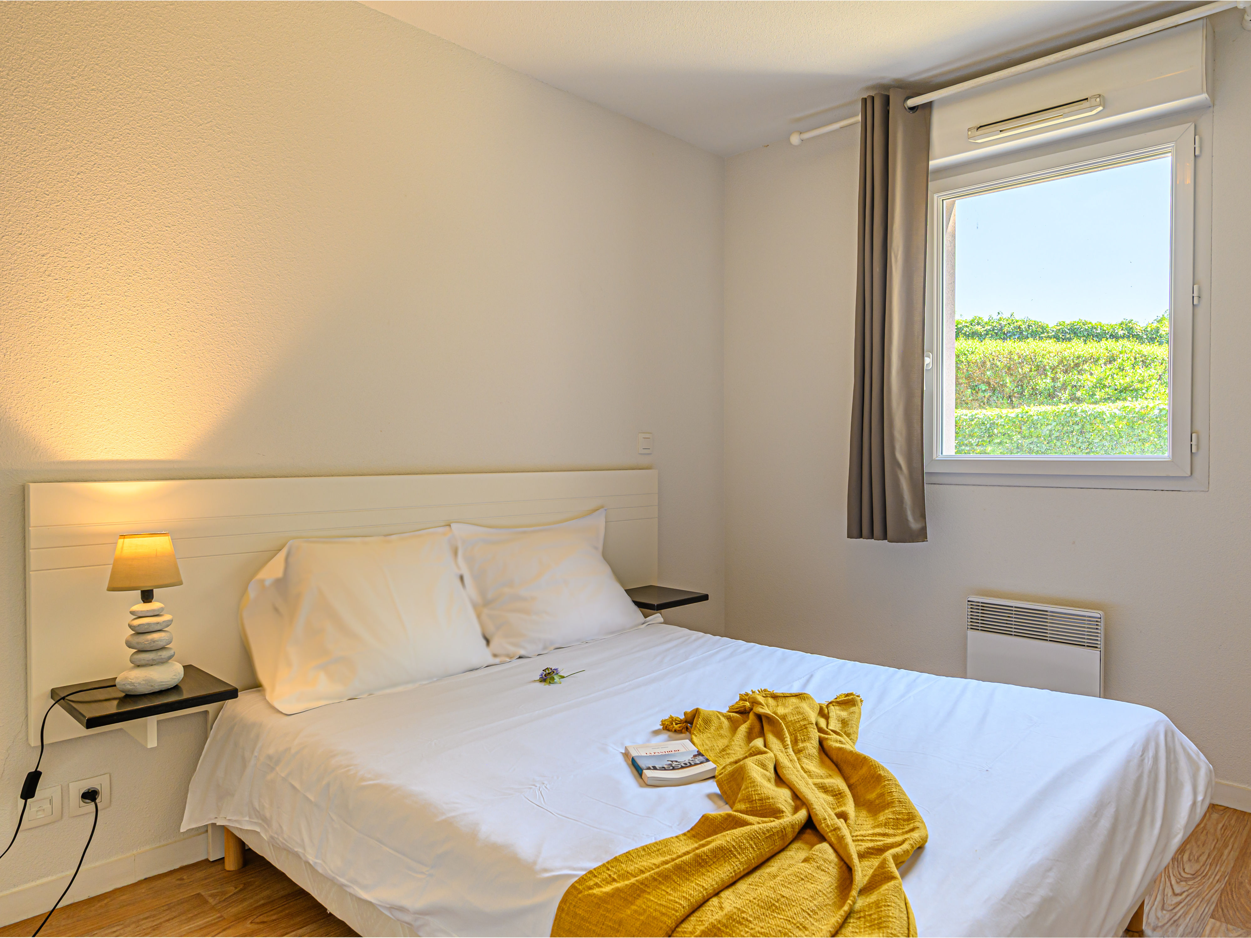 image Relax on the double bed, draped in soft linens with gentle light filling the separate bedroom