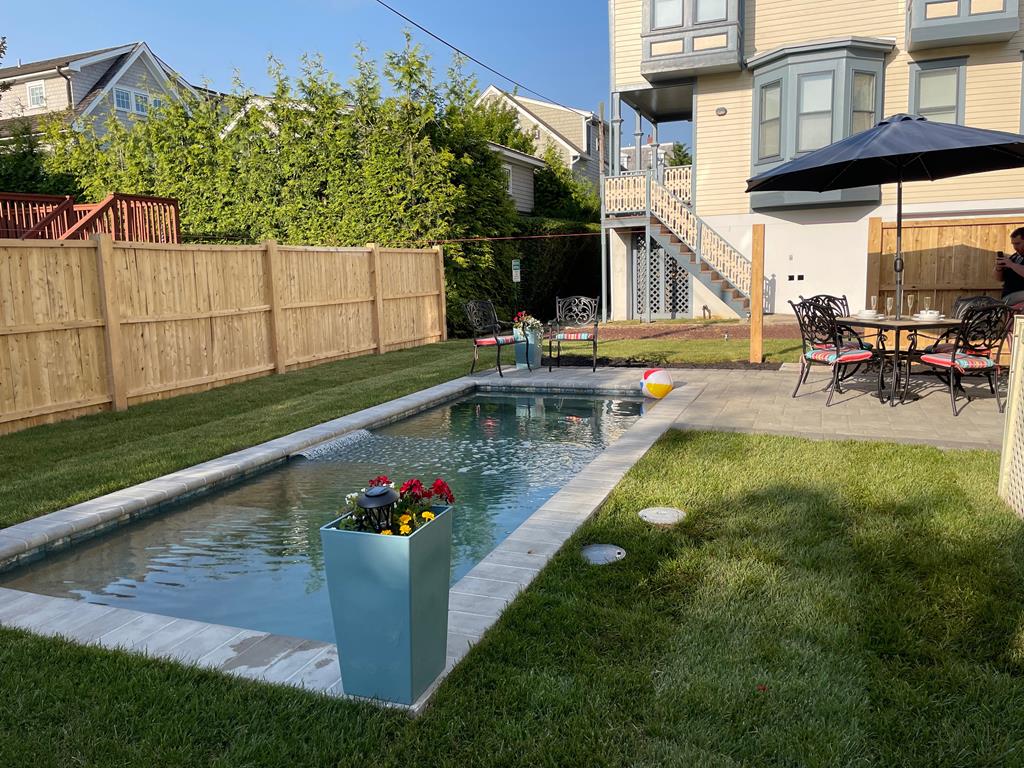 image Dive into relaxation in the serene saltwater pool, complete with colorful seating and vibrant flowers.