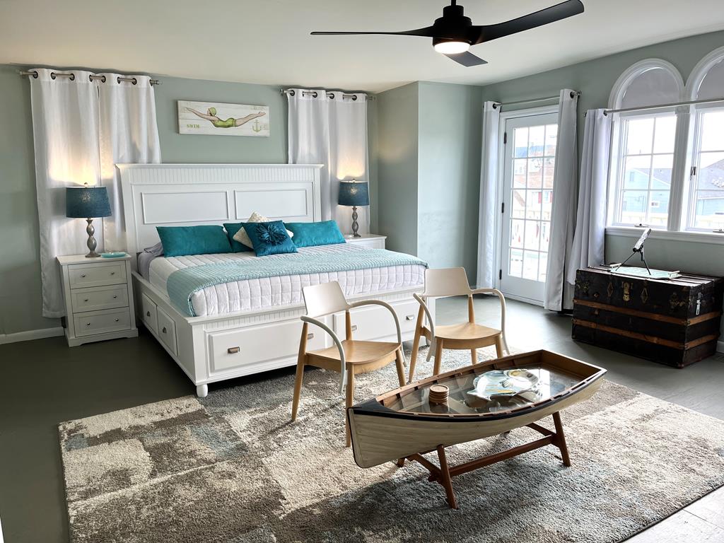 image Awake to serene beach decor and natural light in this inviting bedroom, perfect for a restful night's sleep.