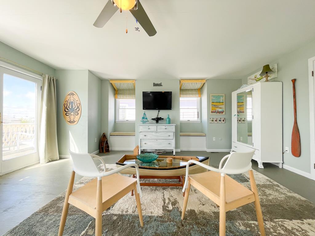 image Relax in this bright living space featuring comfortable seating and beach-inspired artwork for a tranquil vibe.