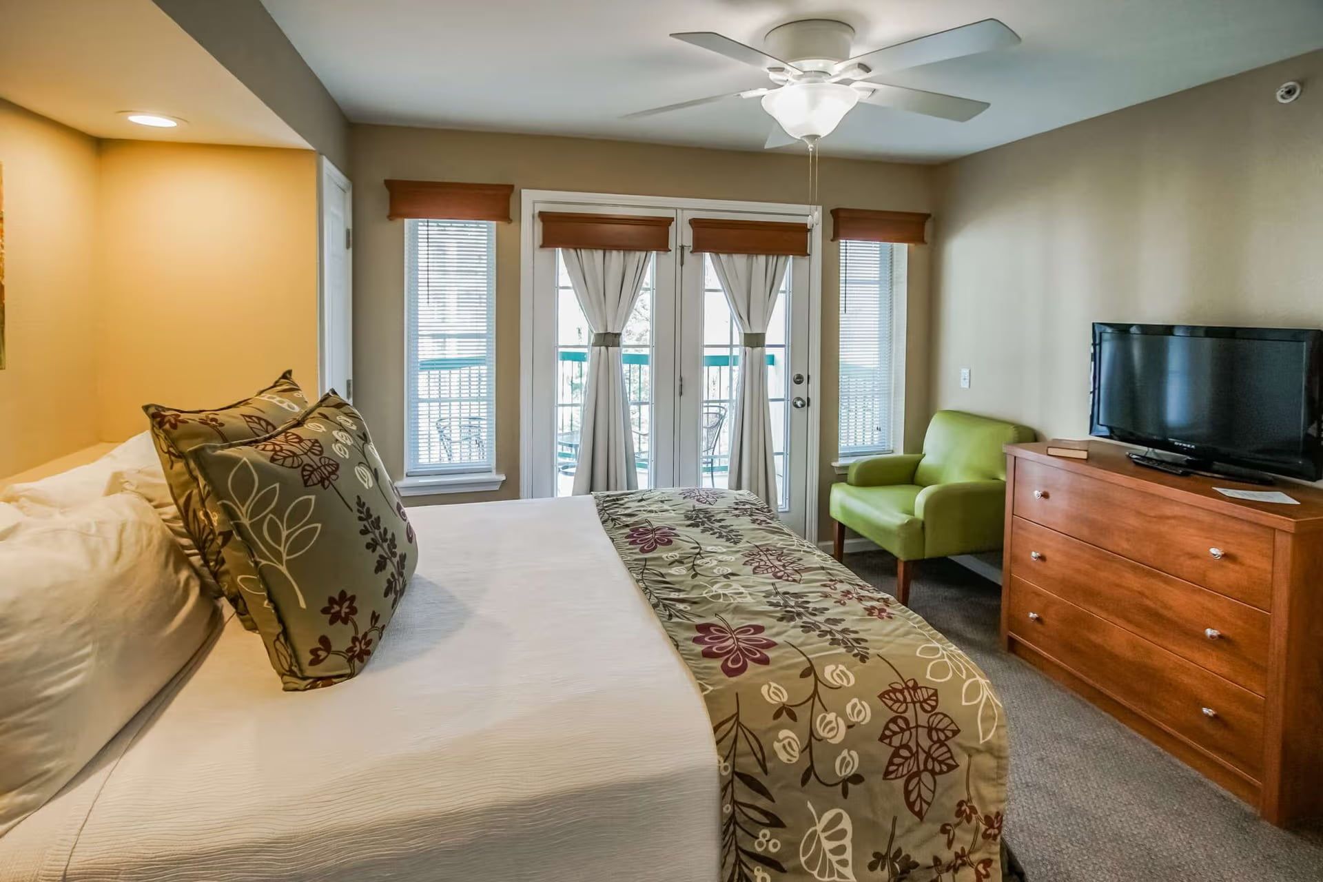 image Queen bedroom with dresser, television, and balcony access.