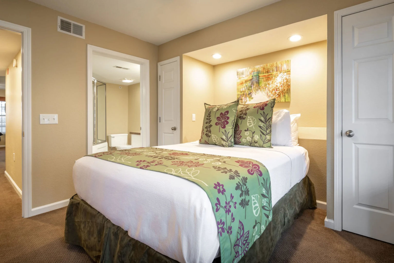image Queen bedroom with green floral bedding and balcony access.