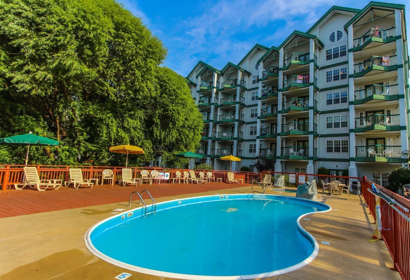 image Outdoor pool with sun loungers and lush resort surroundings.