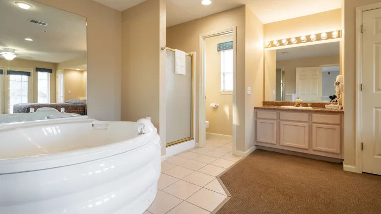 image Luxurious bathroom featuring a jetted tub and double sinks.