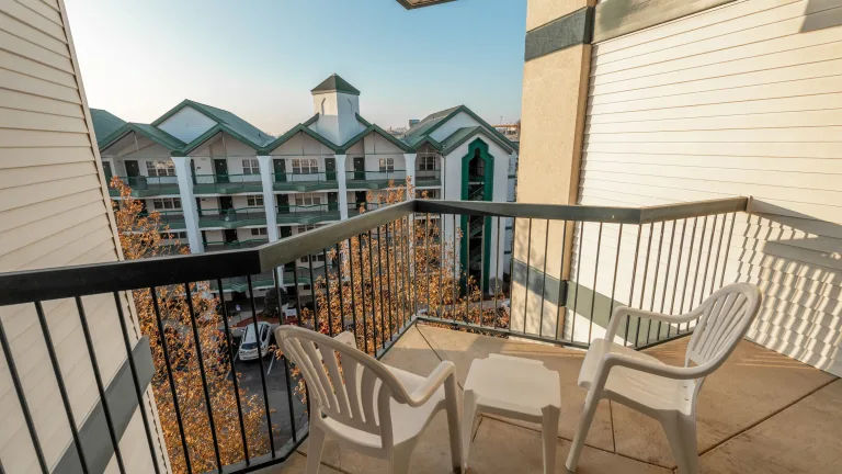 image Private balcony with two chairs overlooking the resort grounds.