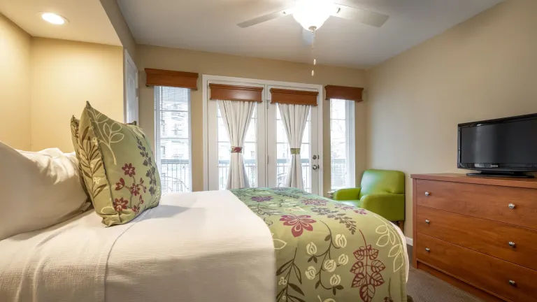 image King-size bedroom with balcony access and warm lighting.