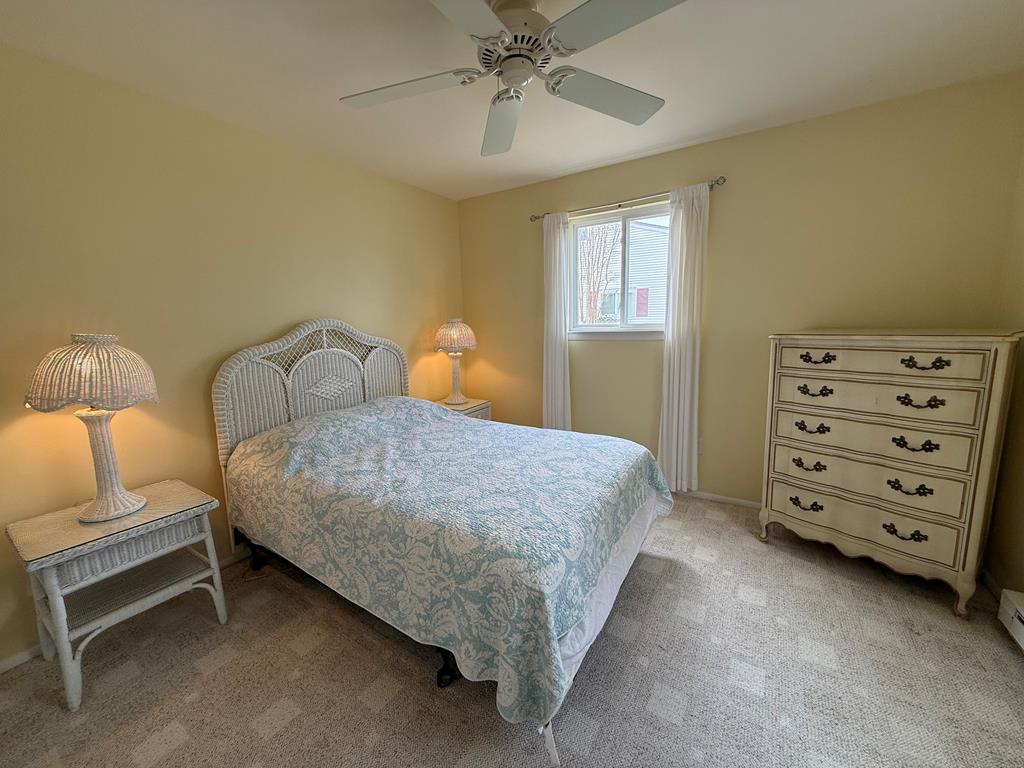 image Comfortable bedroom with a double bed, vintage lamps, dresser, and natural light.