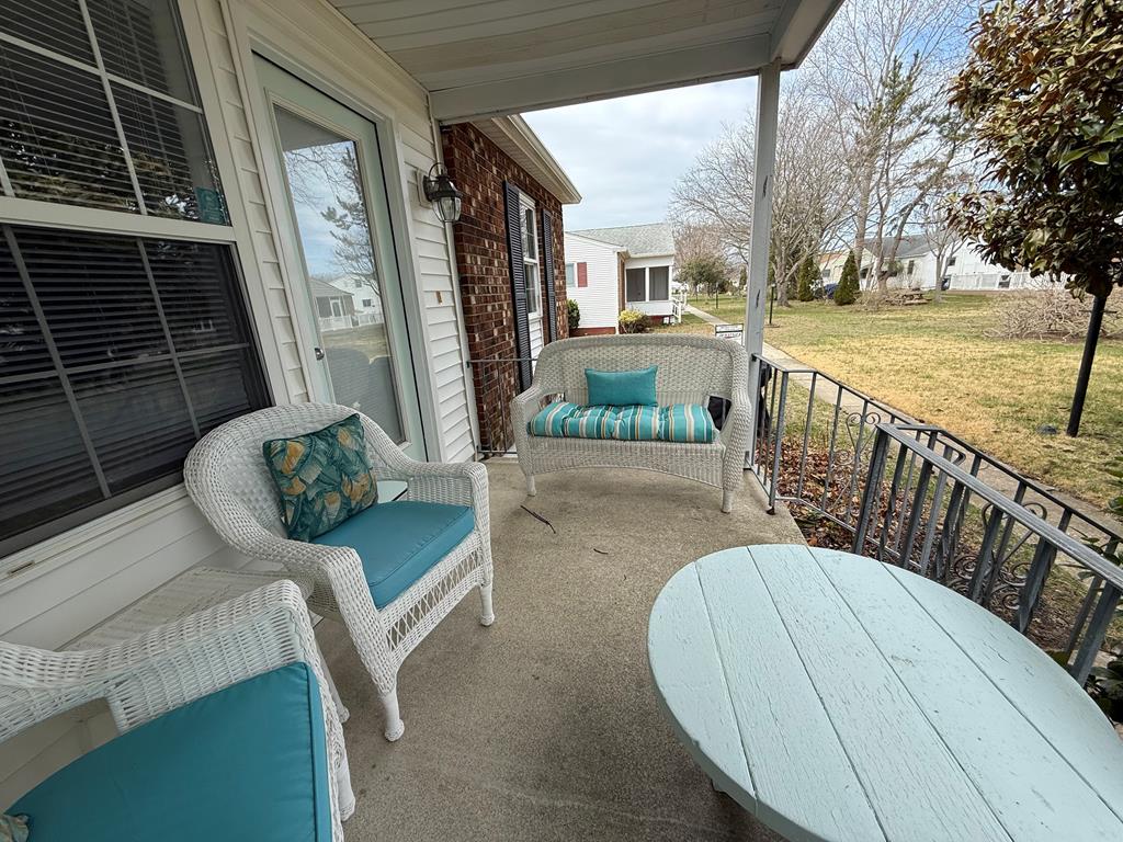 image Charming porch with wicker seating and teal accents, perfect for relaxing outdoors.
