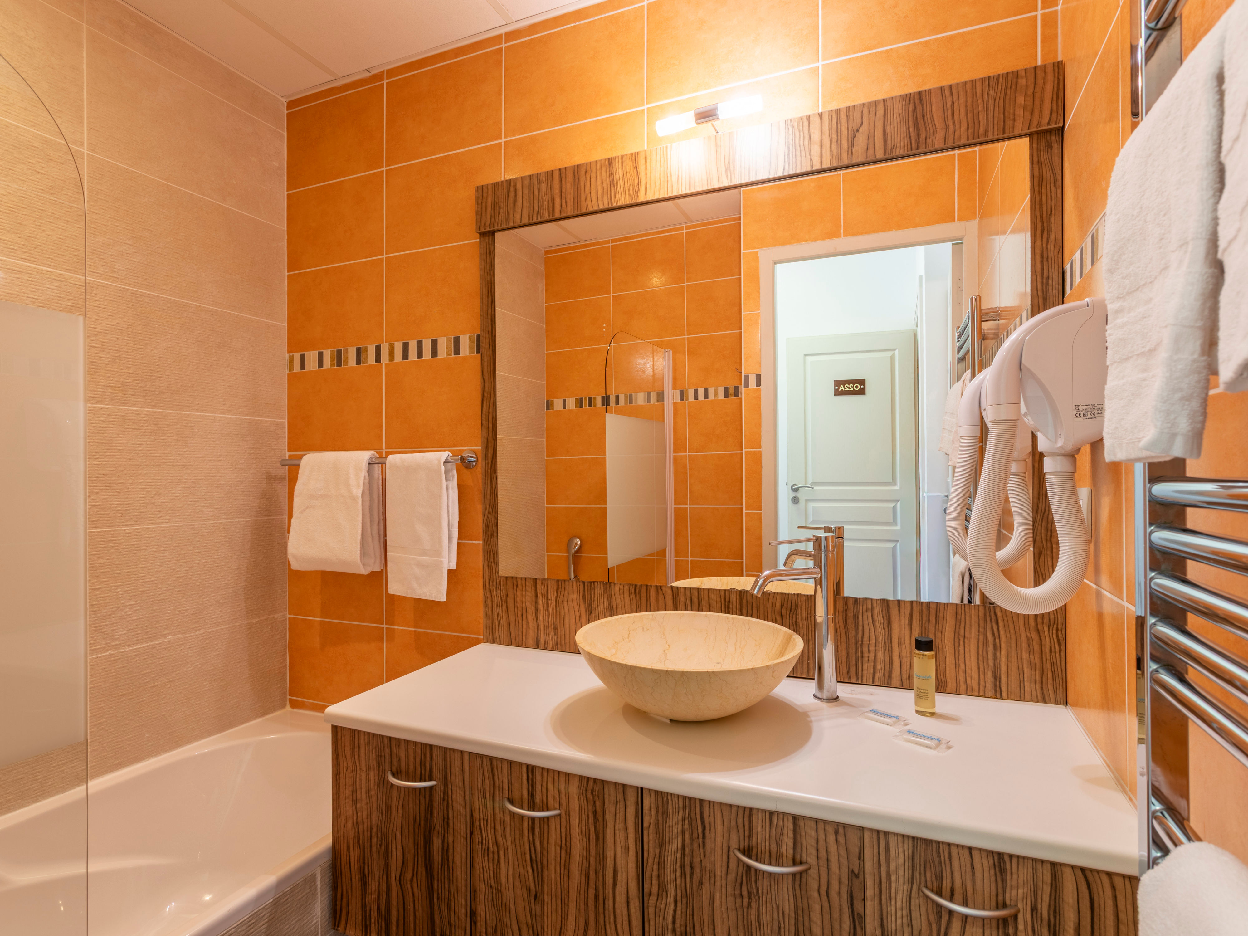 image En-suite bathroom with basin and bathtub, white tile walls, and all the basics for a fresh start
