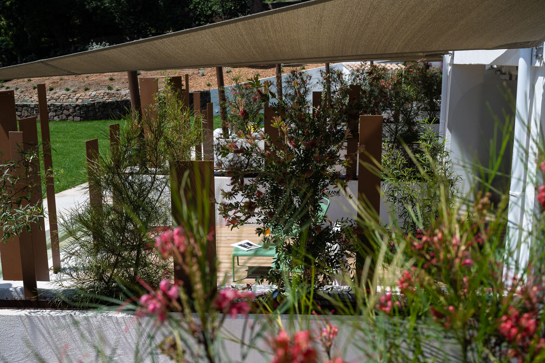 image Garden-level terrace glimpsed through wooden partitions — private and sheltered by foliage