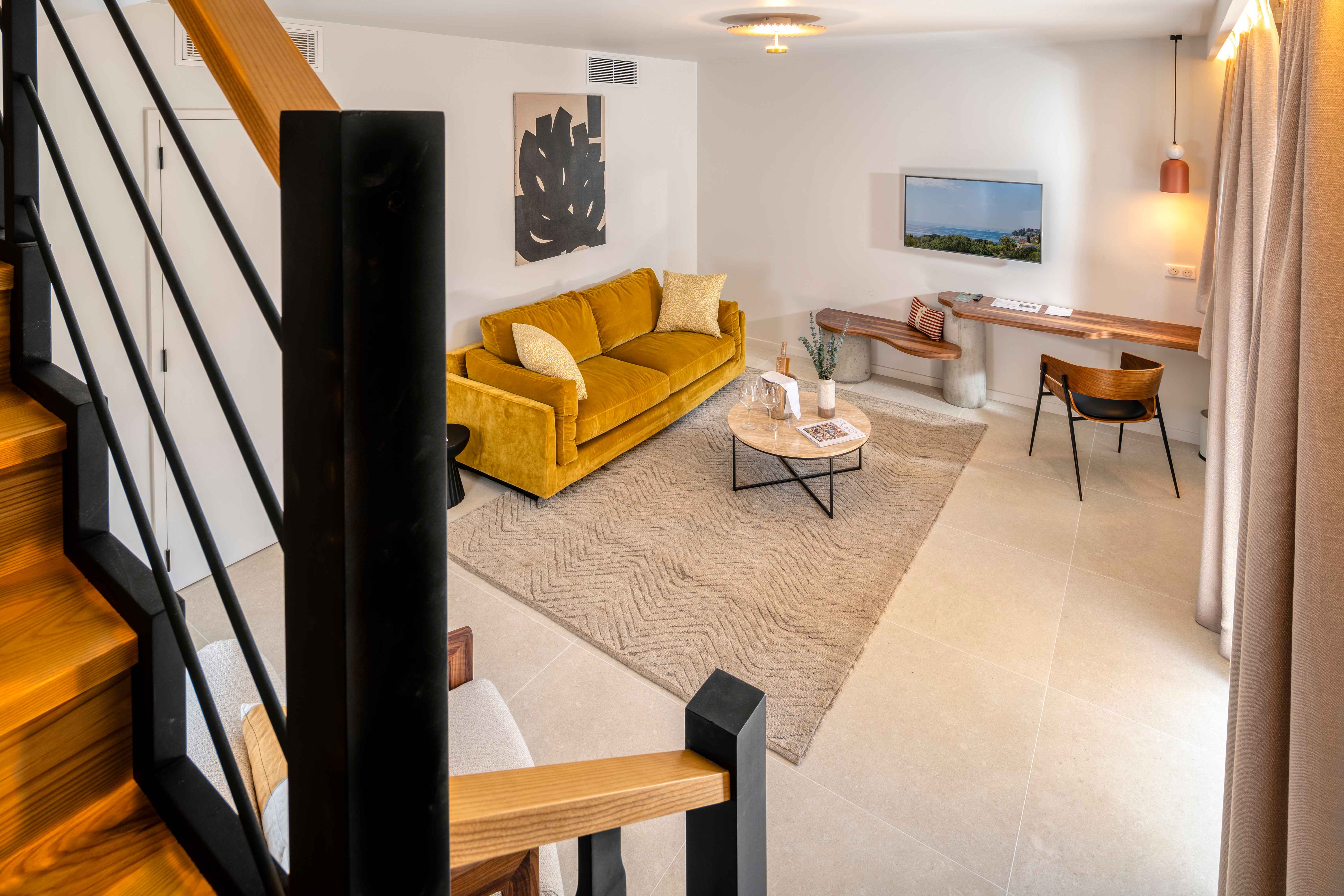 image Mustard-coloured sofa and a round coffee table in the main-level living area of the duplex