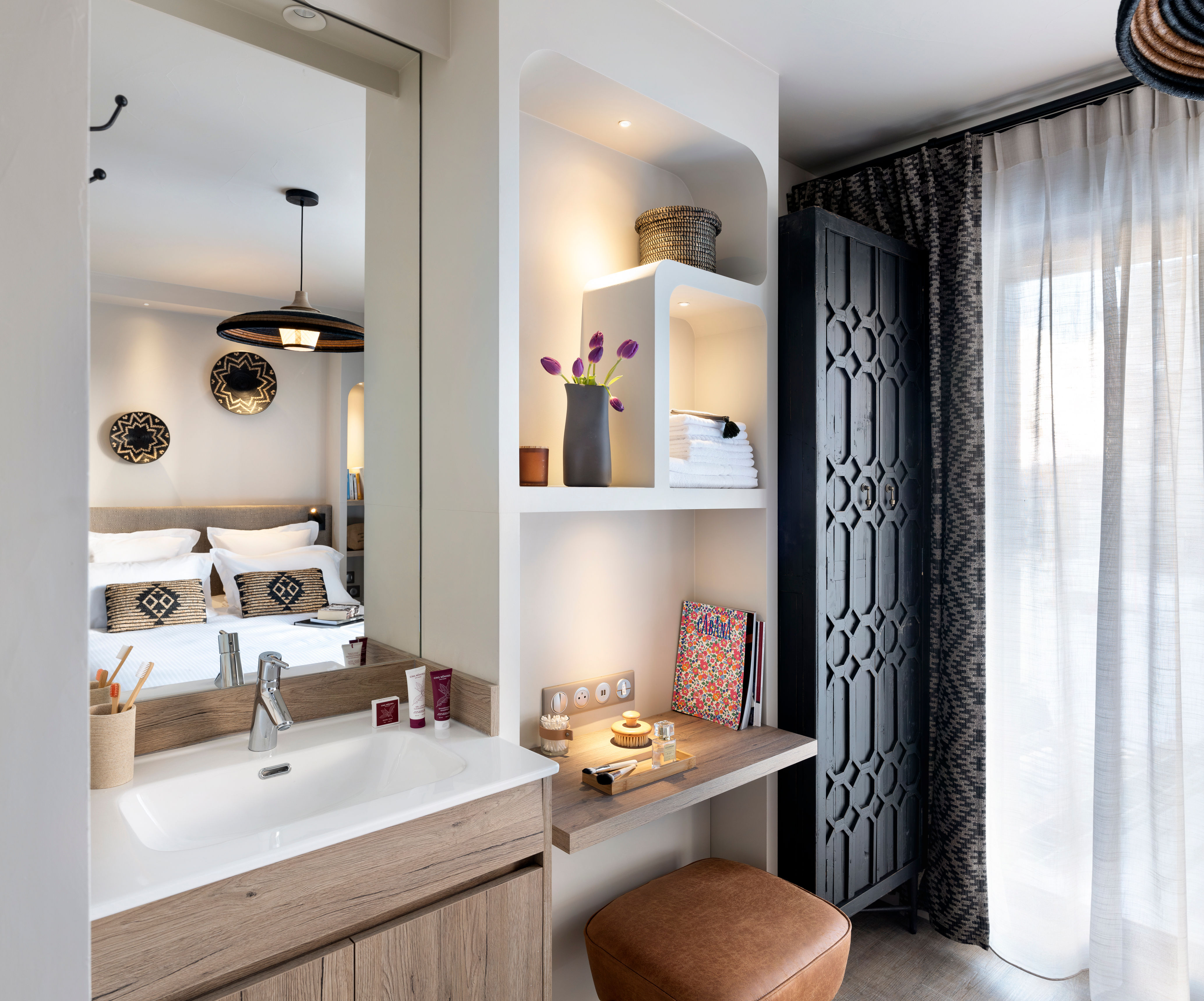 image Vanity area with storage shelving stocked with fresh towels — linens are made up and ready on arrival