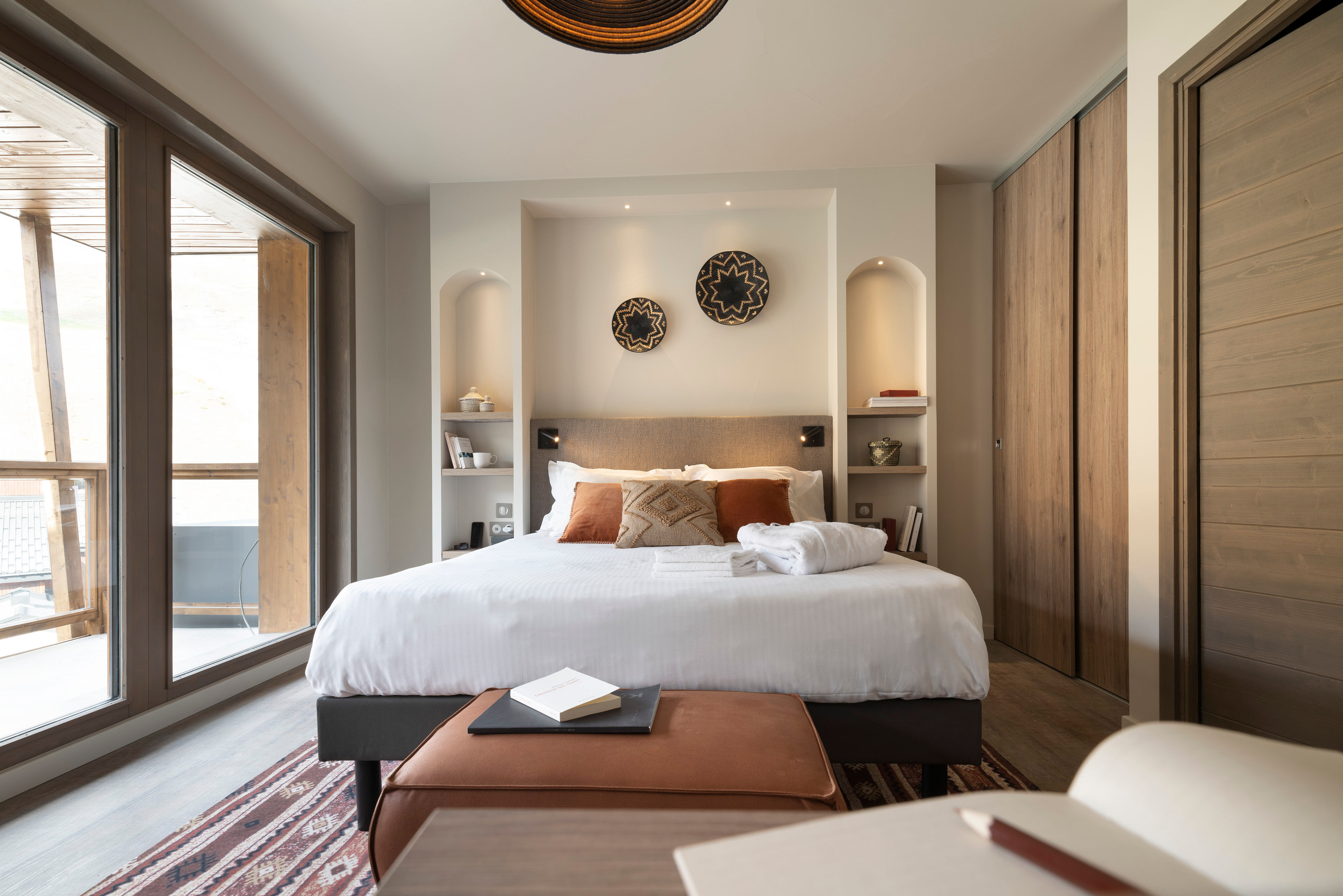 image Main double bedroom with a decorative headboard, warm lighting, and dark-toned wall art