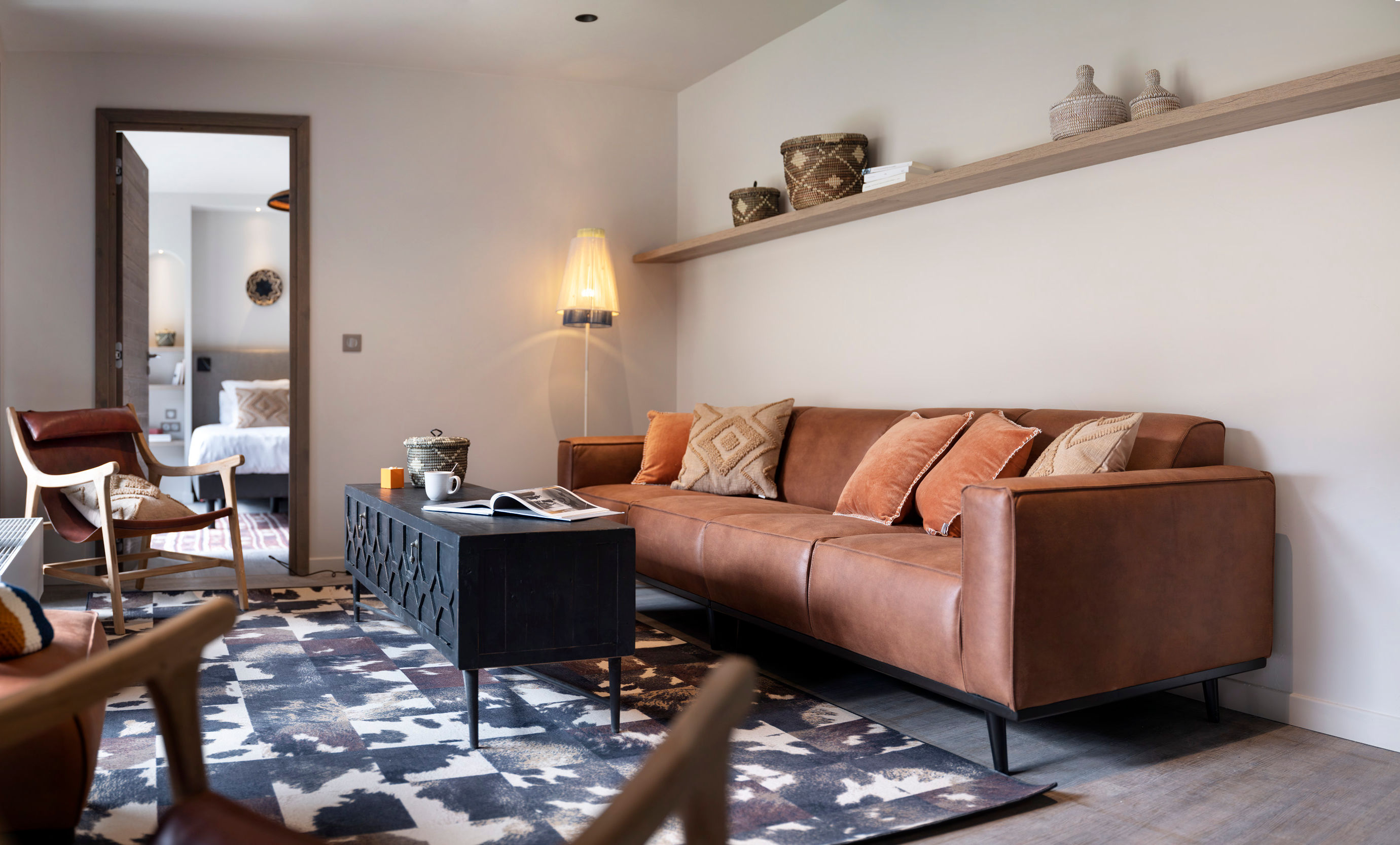 image Second seating area with a leather sofa and a patterned rug — extra breathing room across the triplex levels