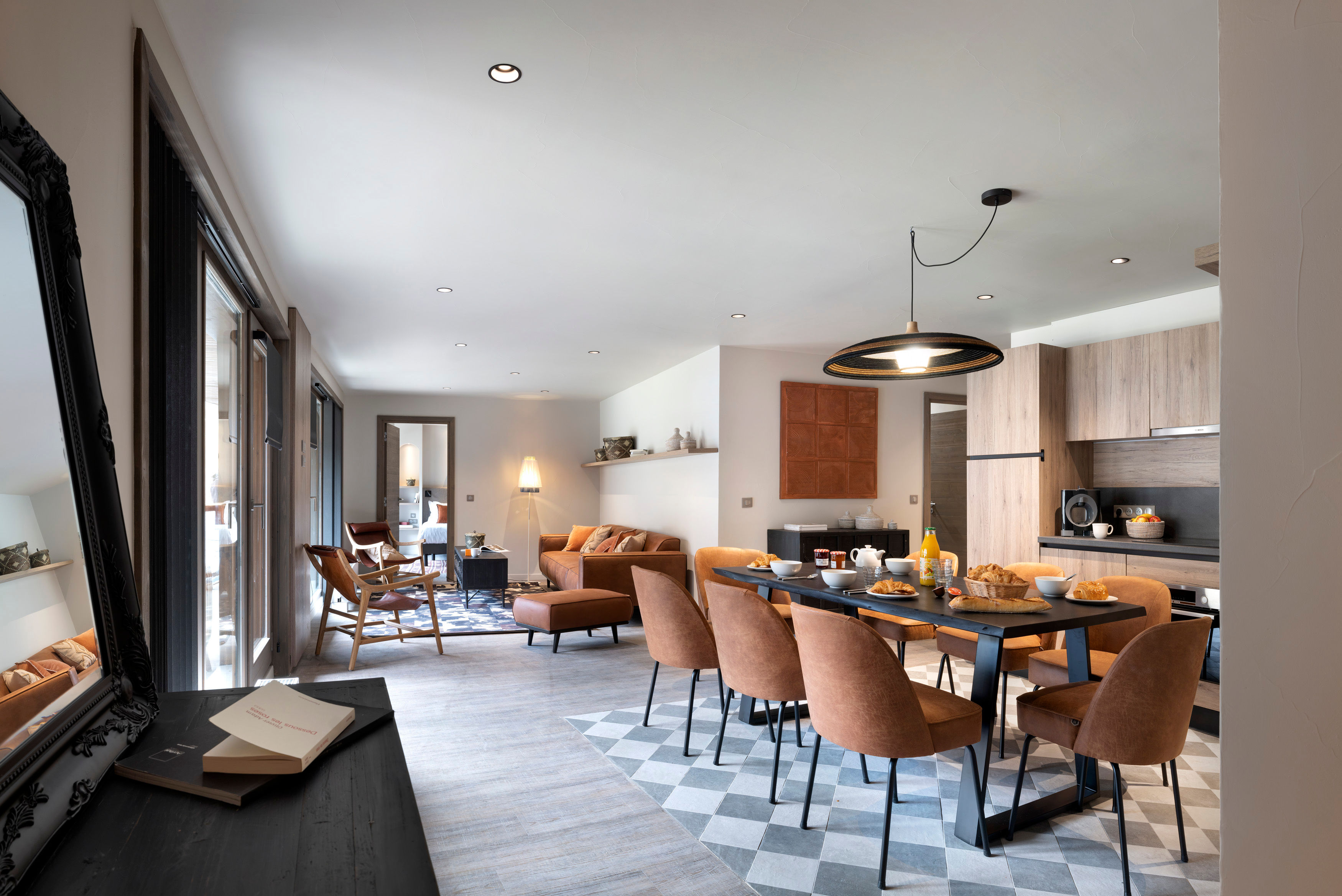 image Long black dining table seats the whole group of eight — large windows bring in the alpine light