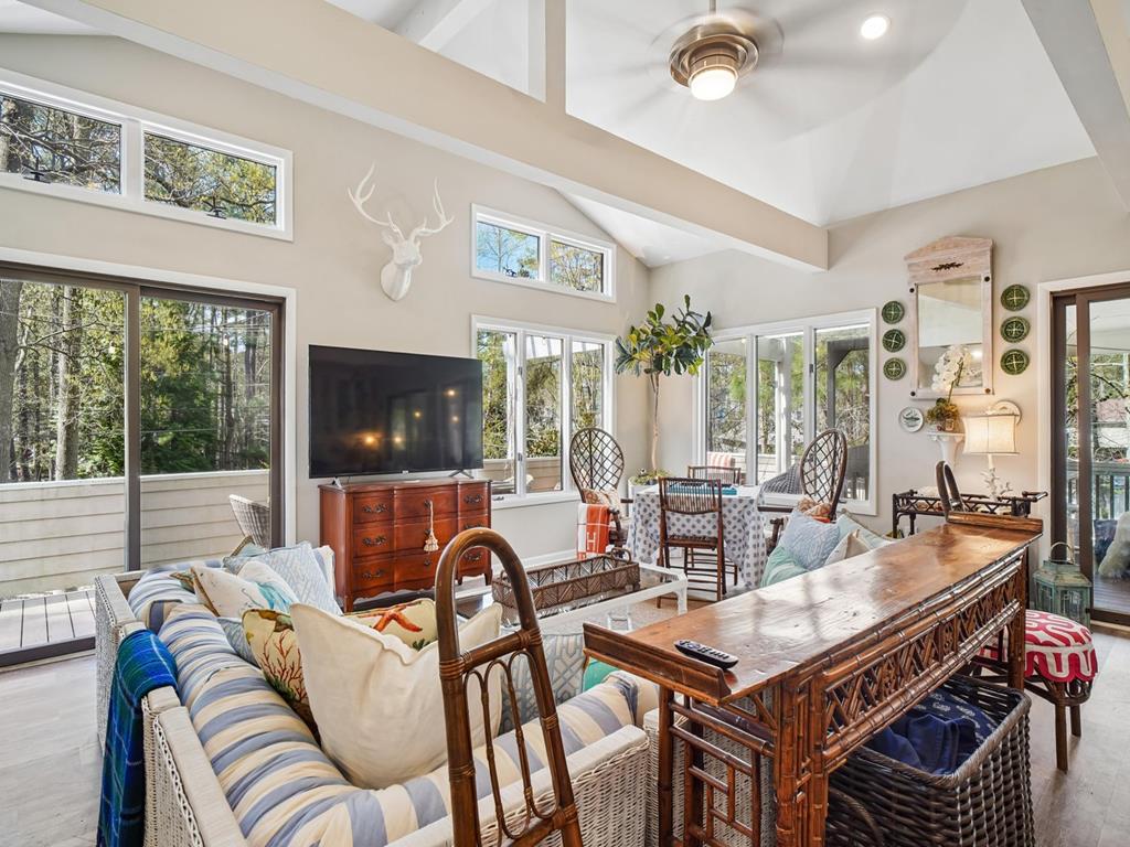 image Floor-to-ceiling windows and armchairs face the wooded backyard from the upper-level living room