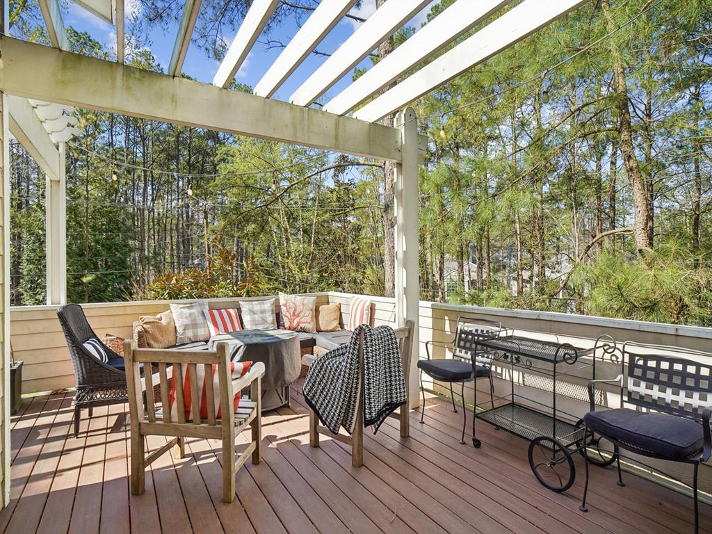 image Deck with two wicker chairs and a side table — a shaded spot for morning coffee in the trees