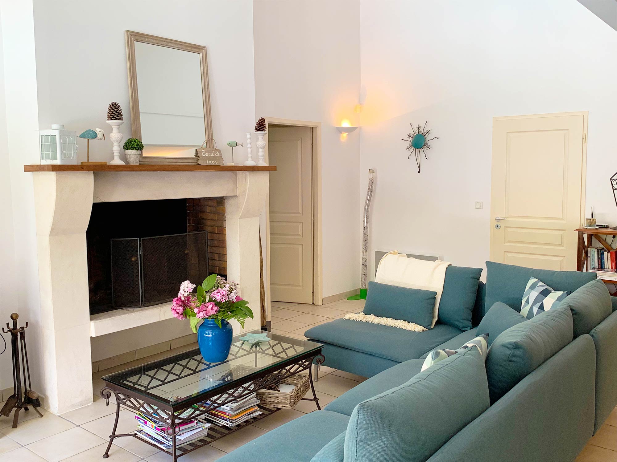 image Teal sofas face a stone fireplace in the living room — a distinctive interior that feels a step above the standard.