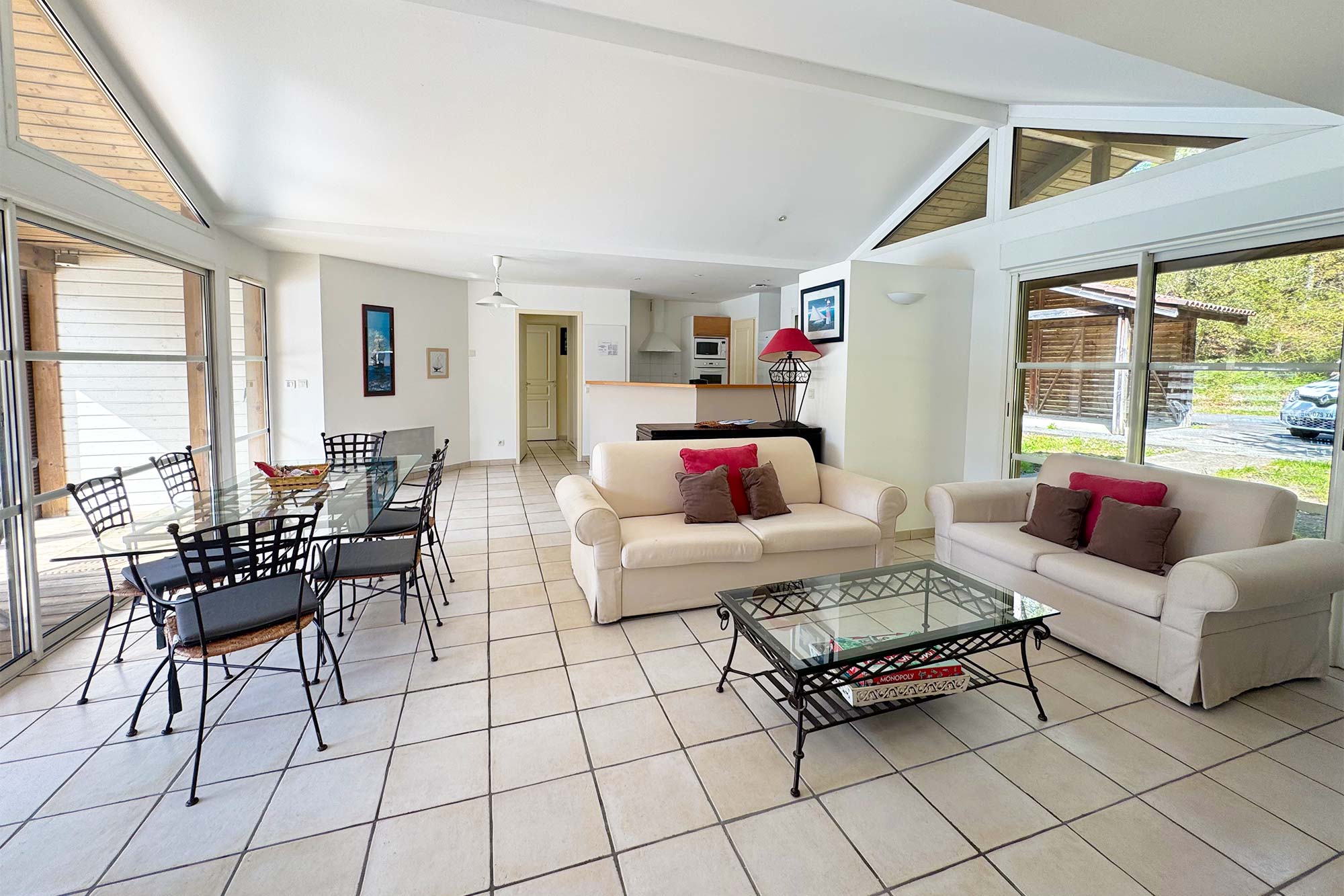 image High ceilings and large windows flood the open-plan living and dining space with light, with the forest garden framed outside.