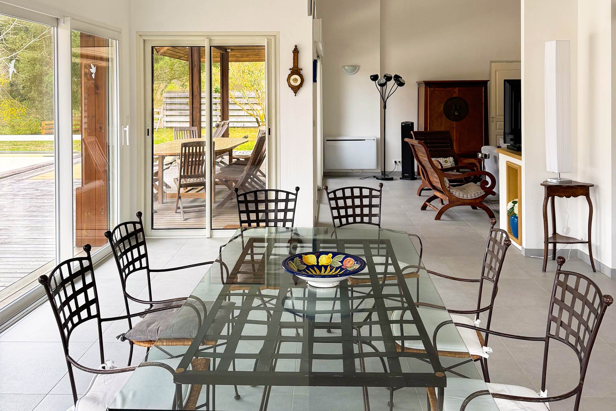 image Dining area, large table, chairs, open to garden through glass doors, forest visible:
The dining area flows straight out to the garden and forest beyond — inside and outside living at its best.