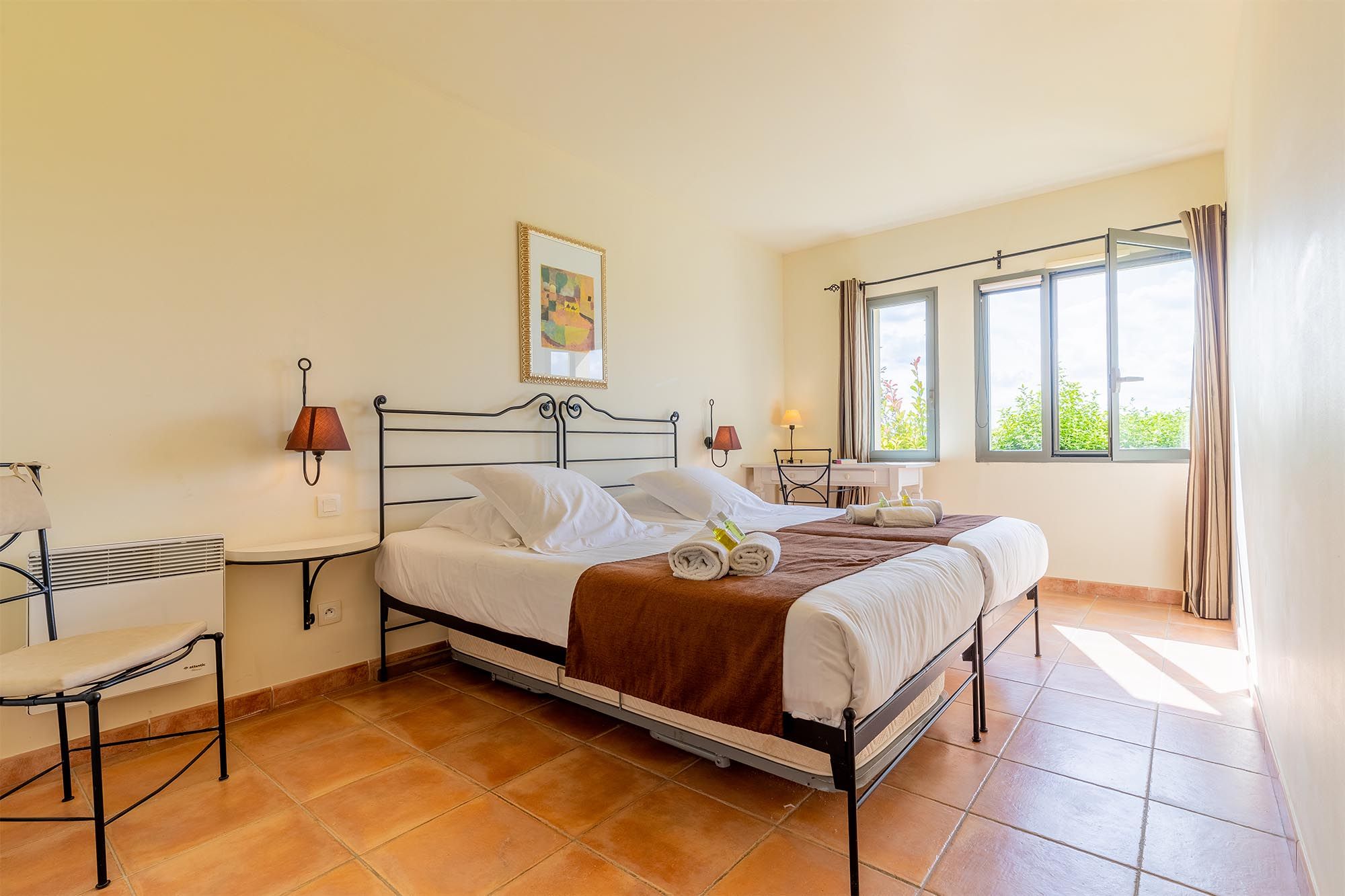image A bright, airy bedroom with garden views and the warmth of a classic Provençal palette.