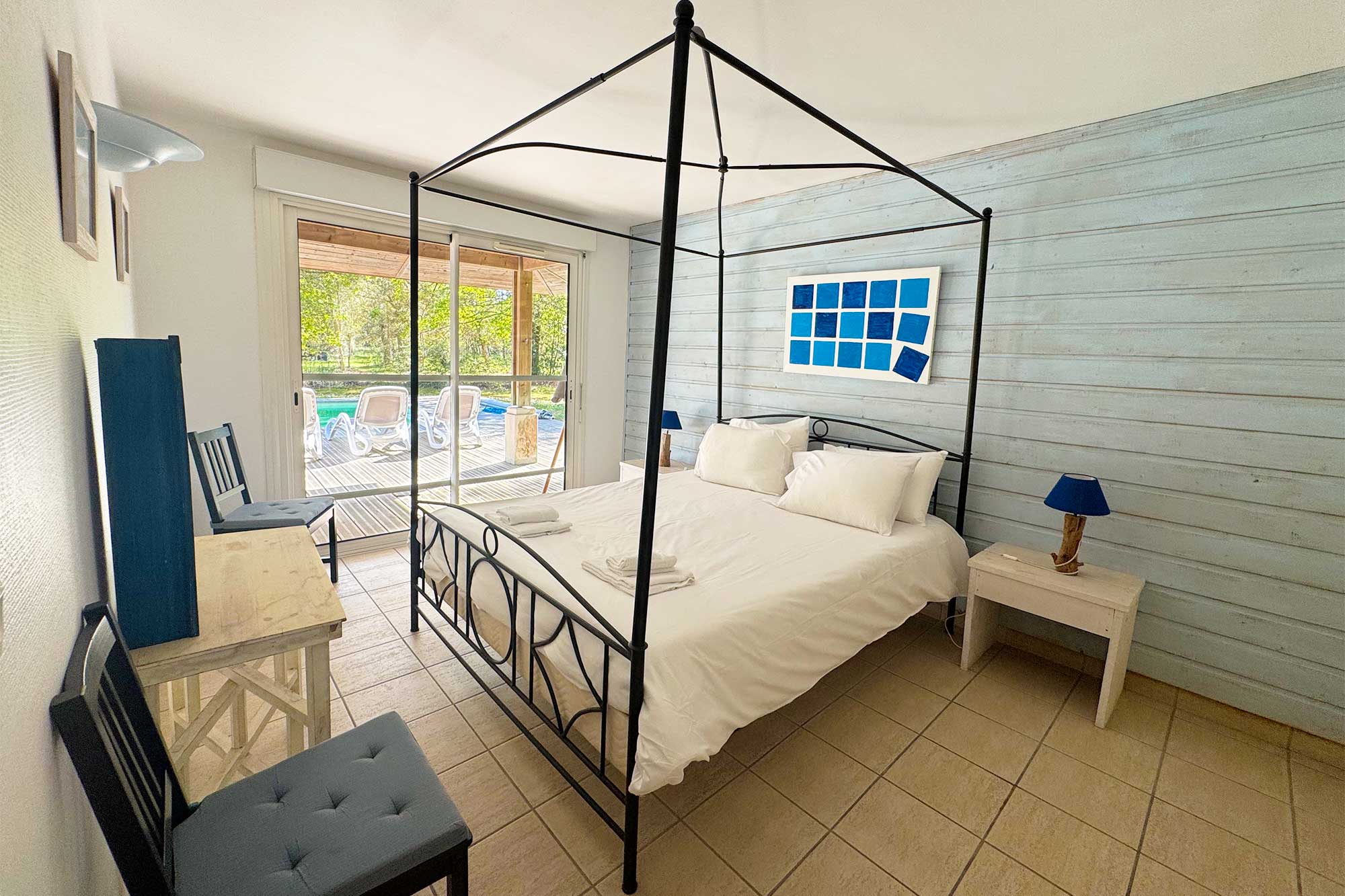 image Double bed with terrace-facing windows — wake up to pine trees and garden light before a day at the beach.