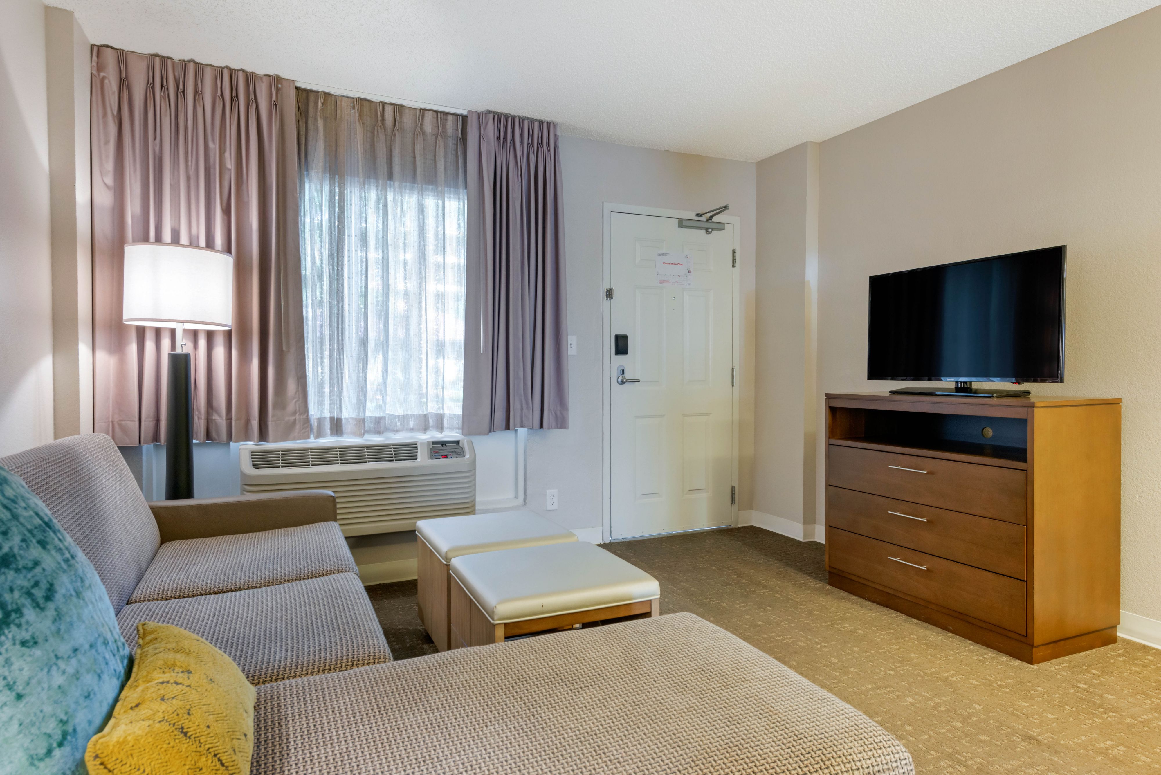 image Living area with a sofa, TV, and lamp.