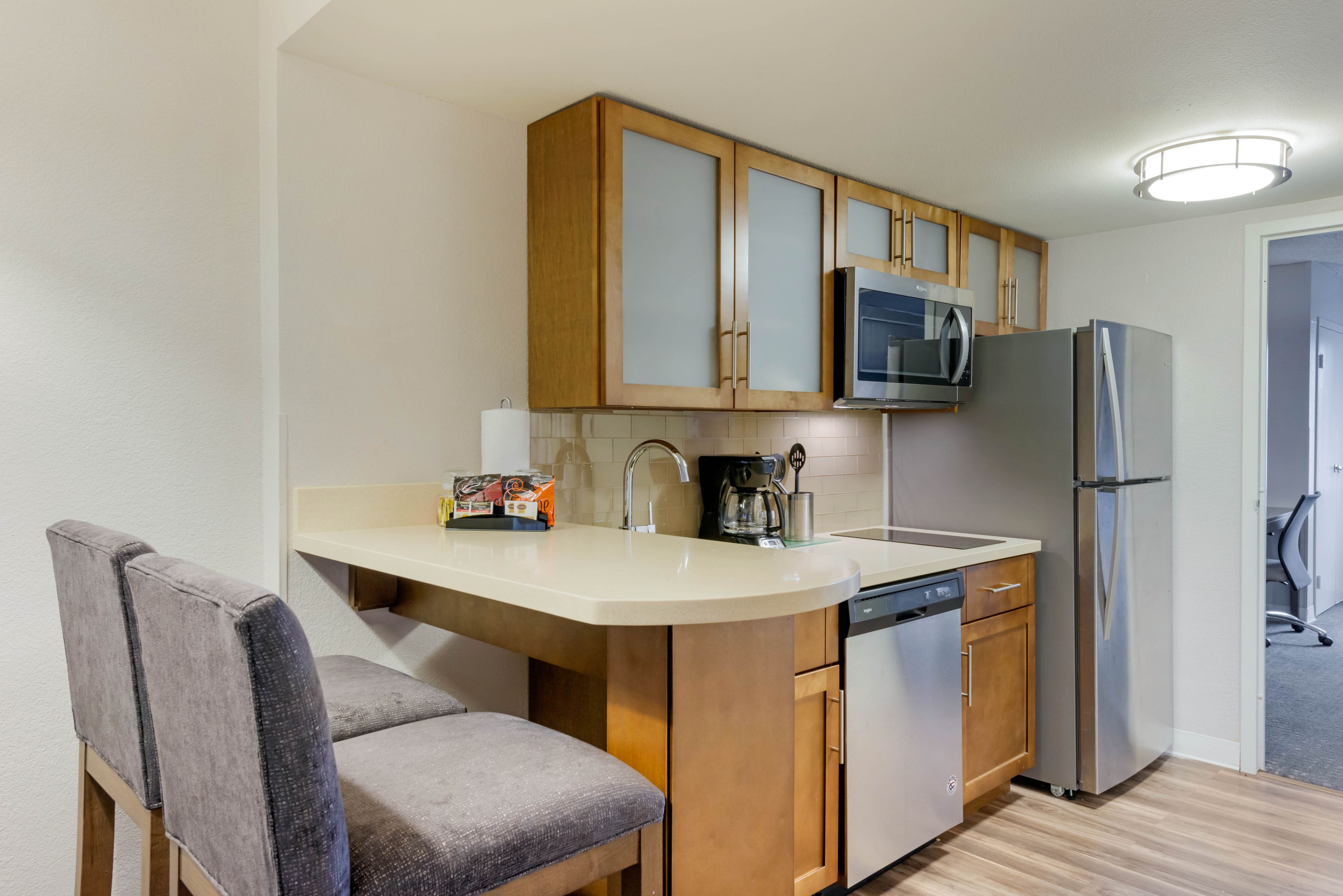 image Modern kitchen featuring stainless steel appliances and bar seating.
